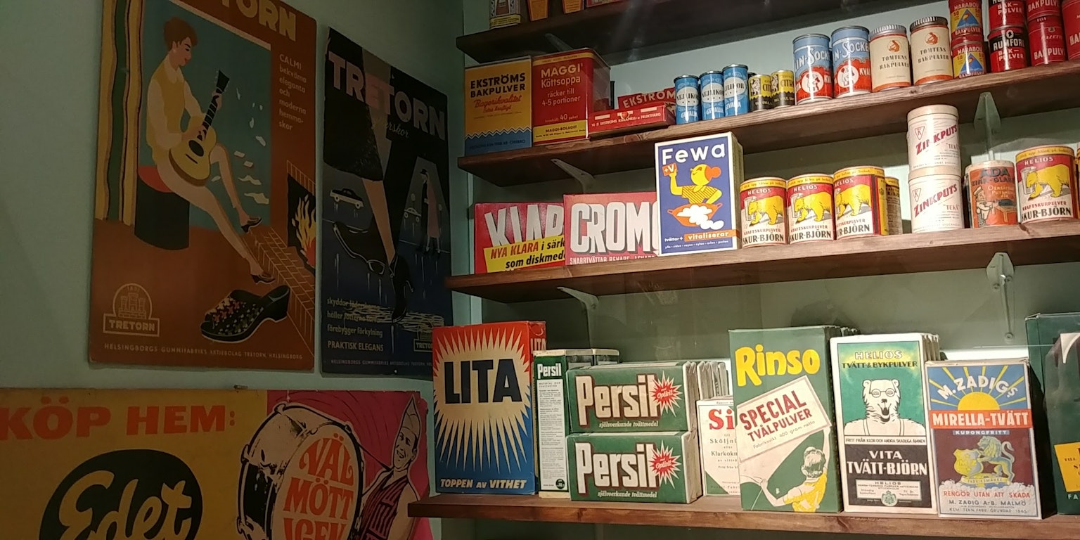 A retro kitchen corner featuring vintage advertisements and canned goods