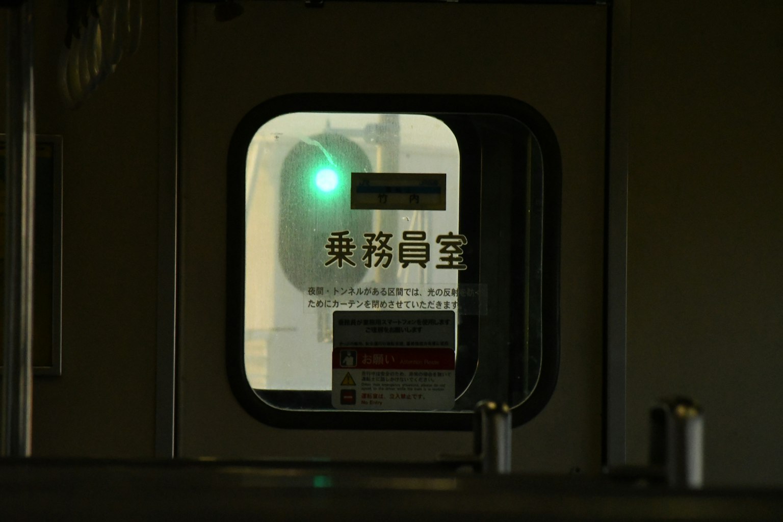 Blick ins Innere eines Bahnhoffensters mit einem grünen Signal