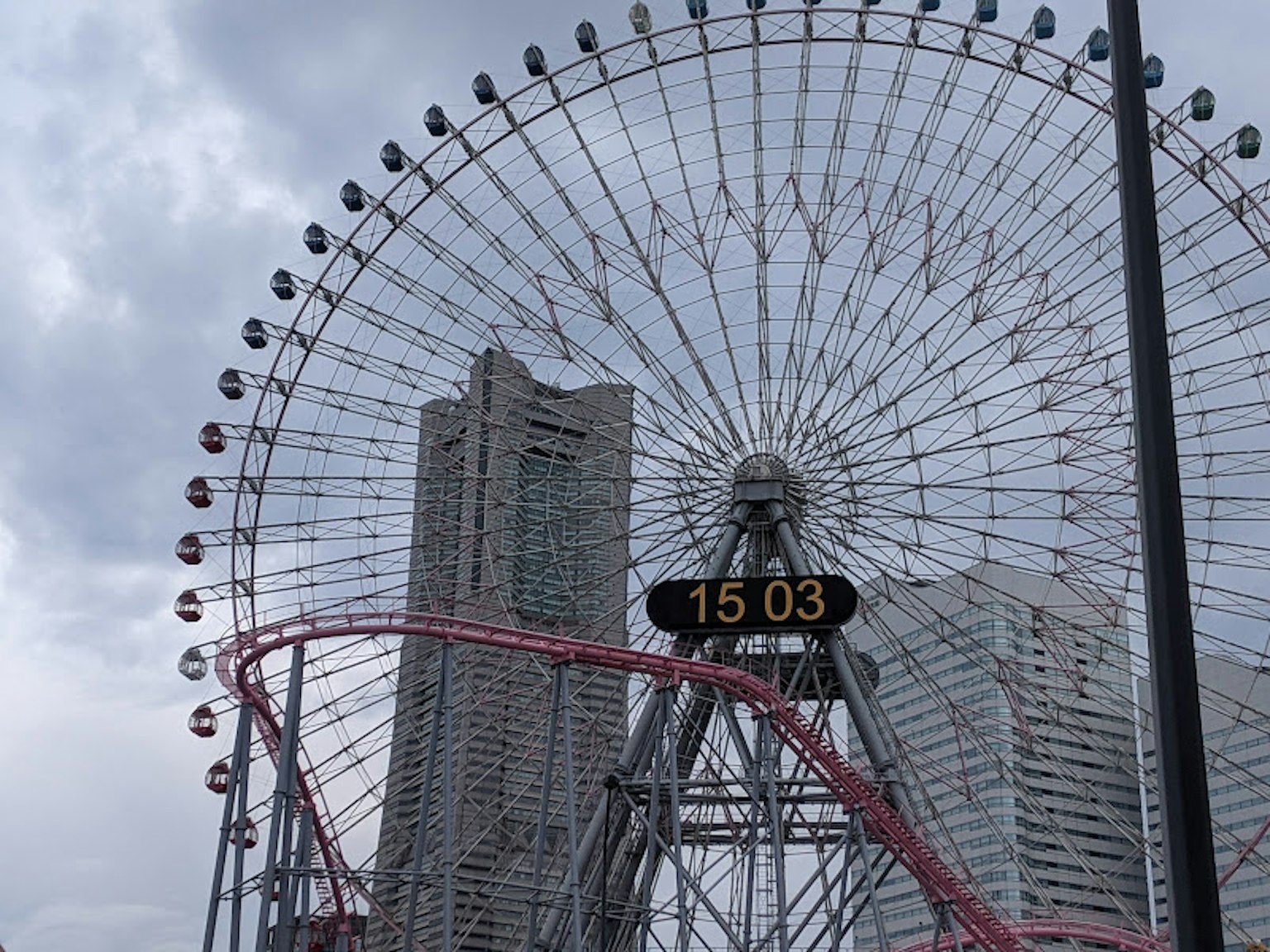 Ferris wheel dan gedung pencakar langit dengan tampilan jam