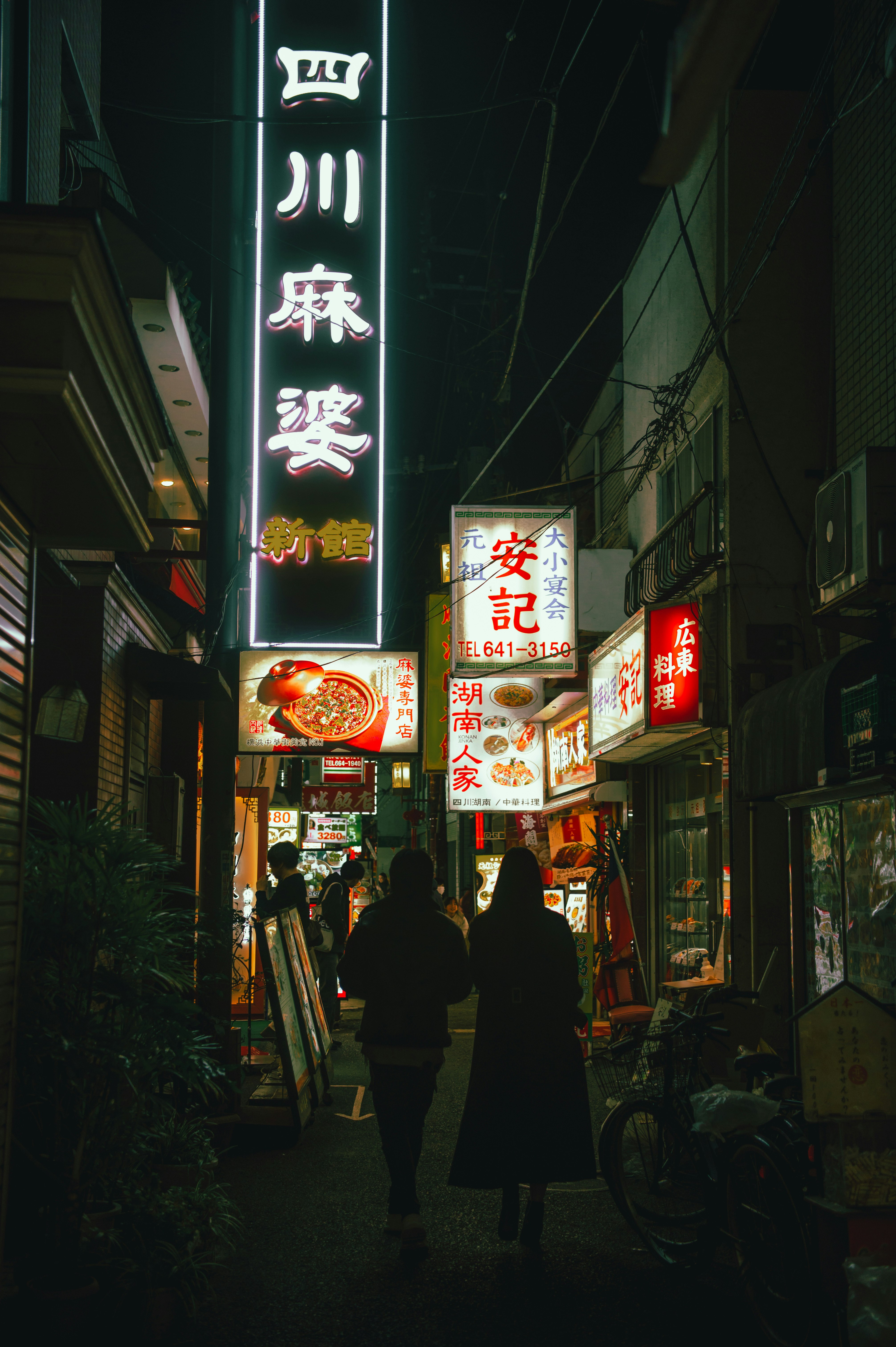 横浜の夜の路地に並ぶ看板と飲食店の灯り