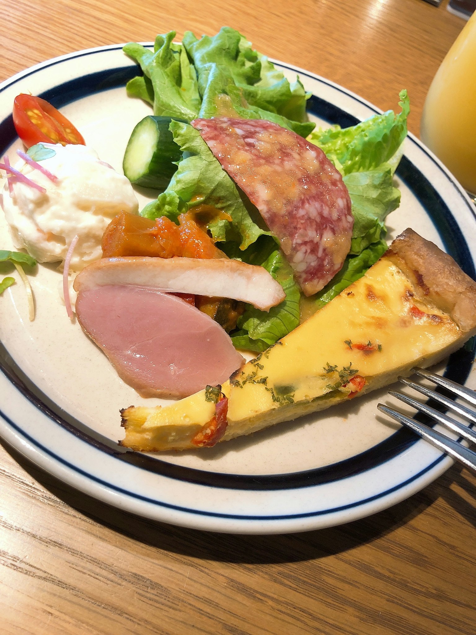 Plato de quiche acompañado de ensalada y rodajas de jamón