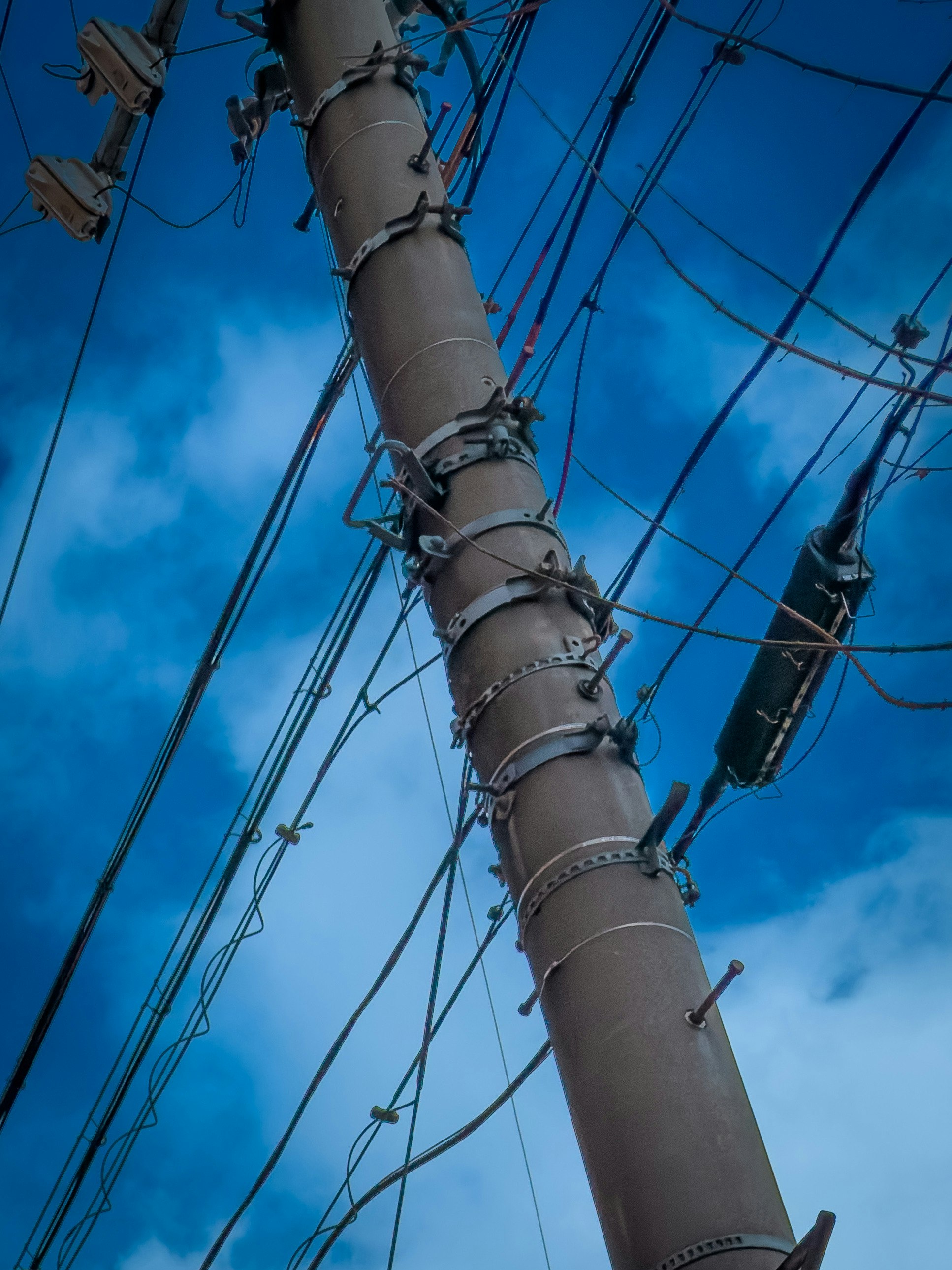 青空に伸びる電柱と電線のある空の風景