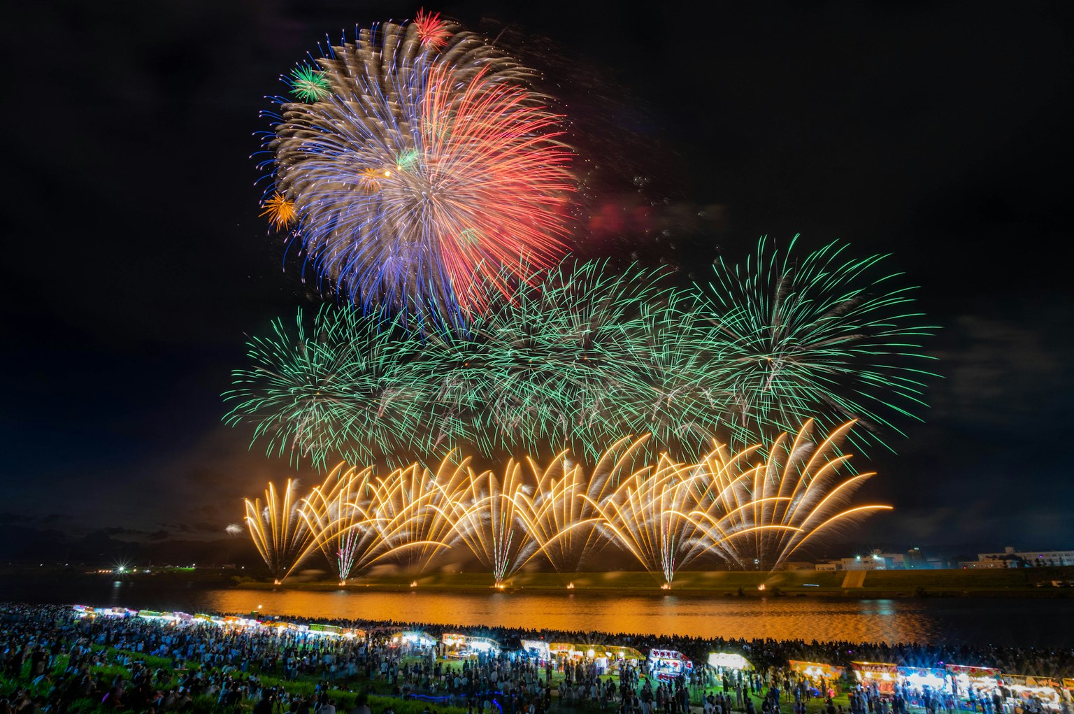 Spectacle de feux d'artifice colorés illuminant le ciel nocturne avec une foule en dessous