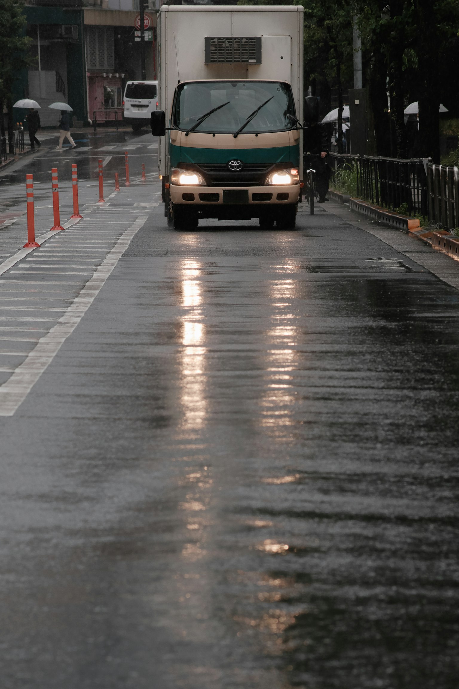 Camion roulant sur une route mouillée sous la pluie avec des reflets