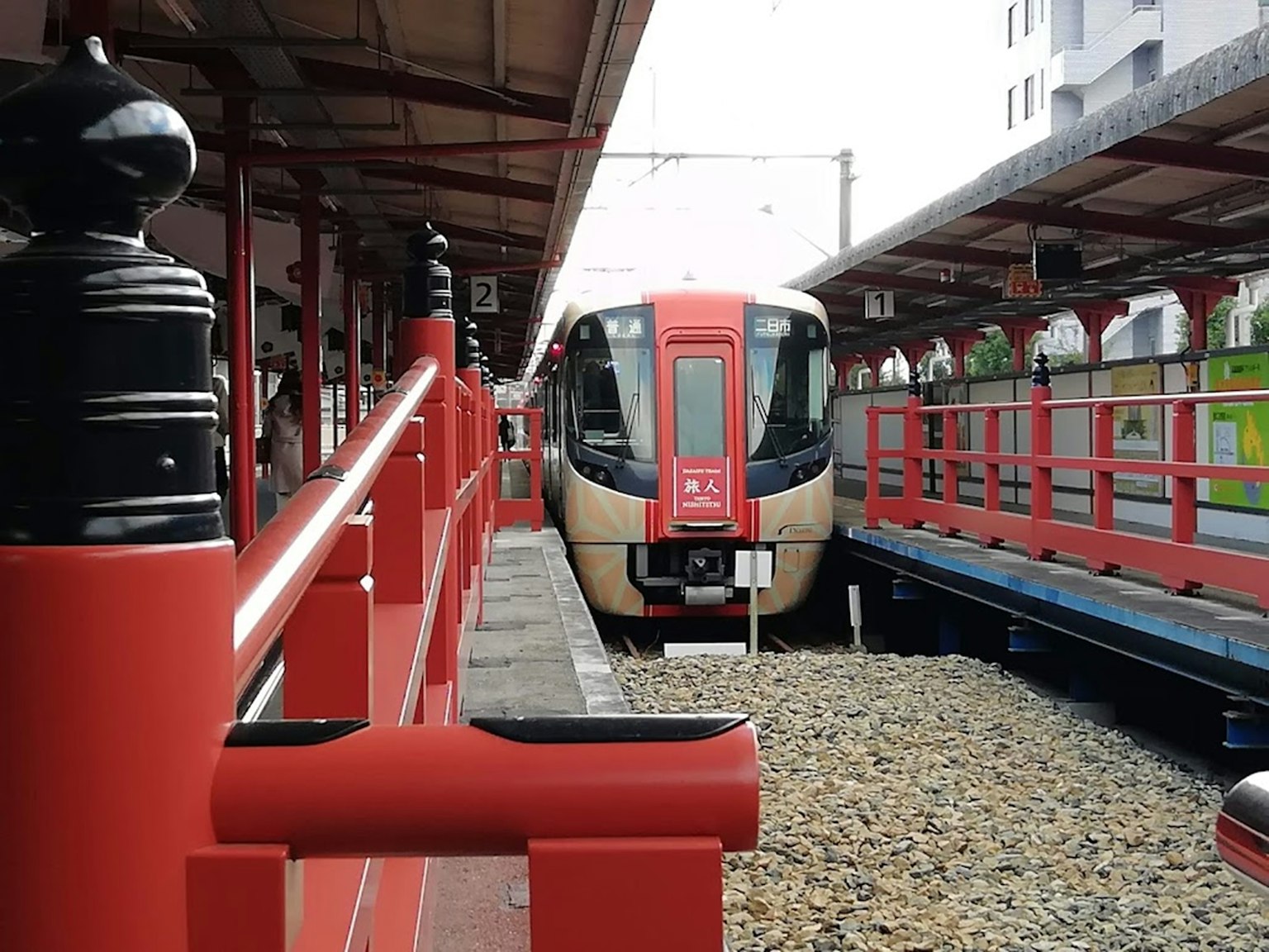Tàu tại ga với lan can đỏ và thiết kế hiện đại