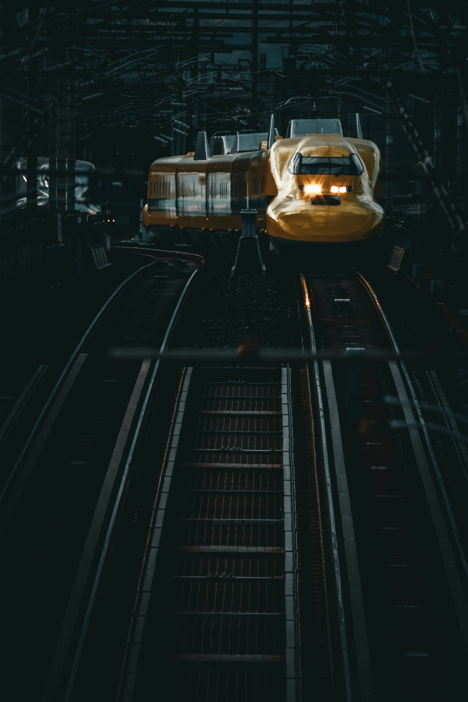 Một chuyến tàu Shinkansen sáng đang tiến đến trên đường ray tối