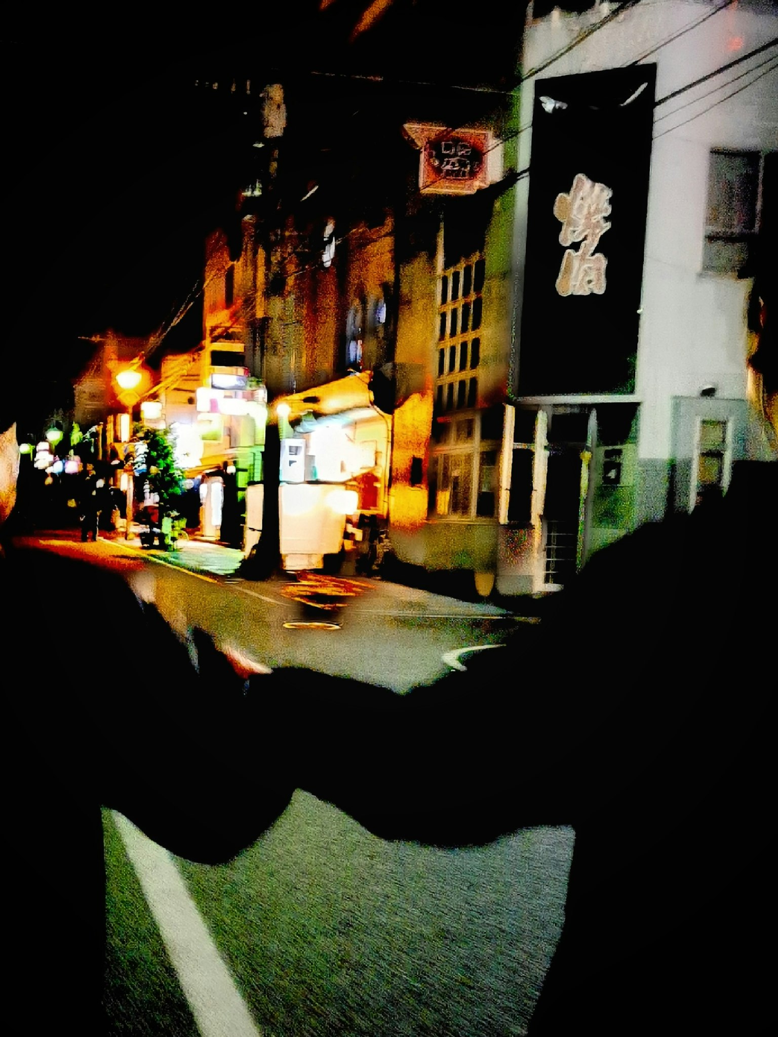 Two people holding hands while walking in a night street