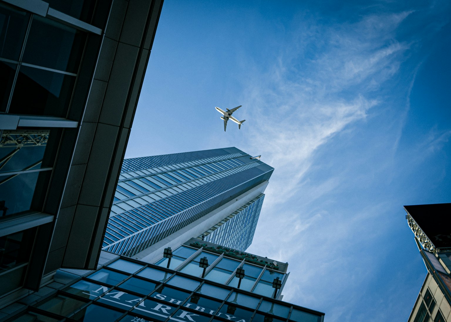 Un avion volant dans le ciel au-dessus de grands immeubles