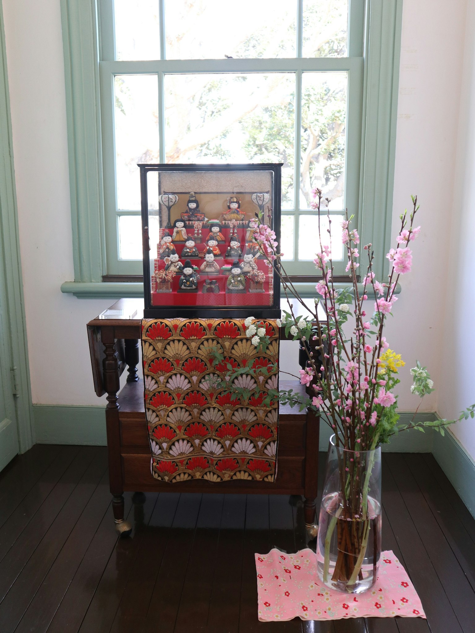 Oggetti decorativi e fiori disposti su un tavolo vicino a una finestra