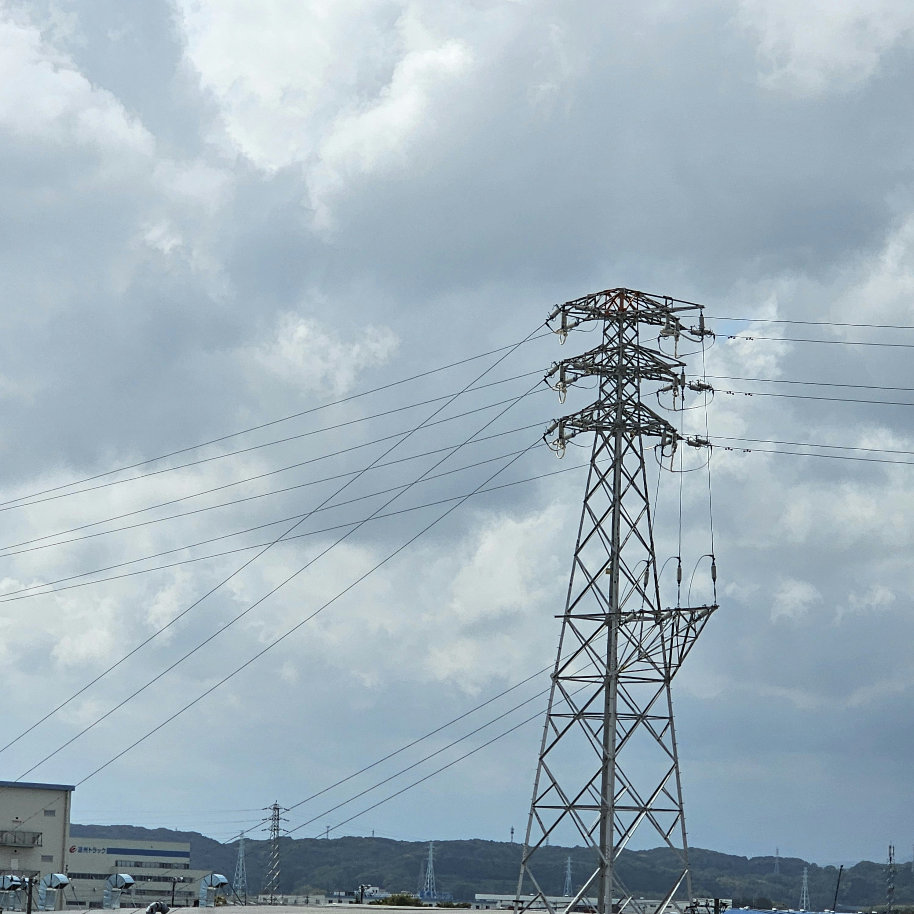 cielo con nubes y torre de transmisión eléctrica