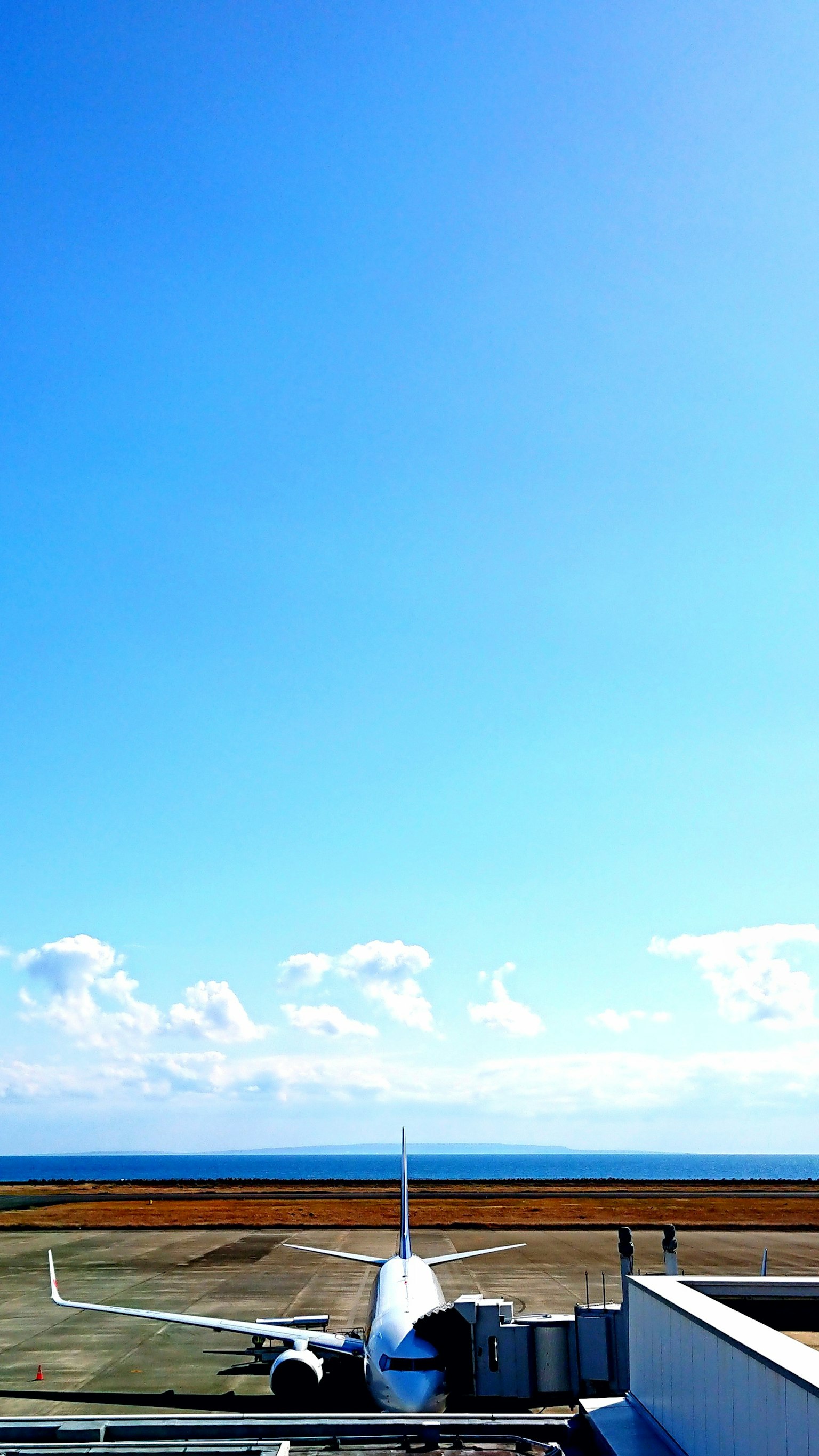 Pista dell'aeroporto con un aereo sotto un cielo blu chiaro