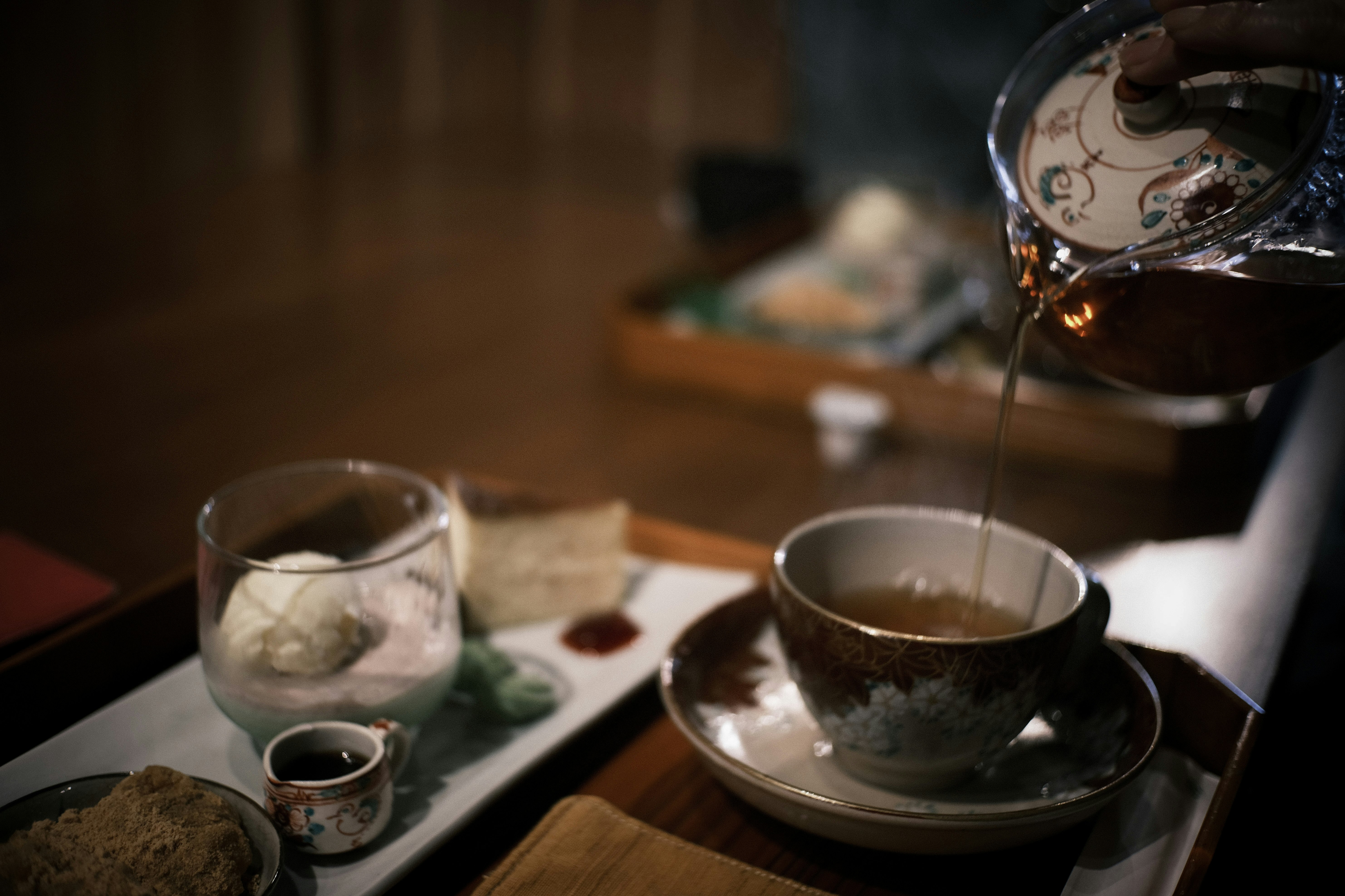 Japanese black tea being poured into a teacup in a traditional old-house cafe
