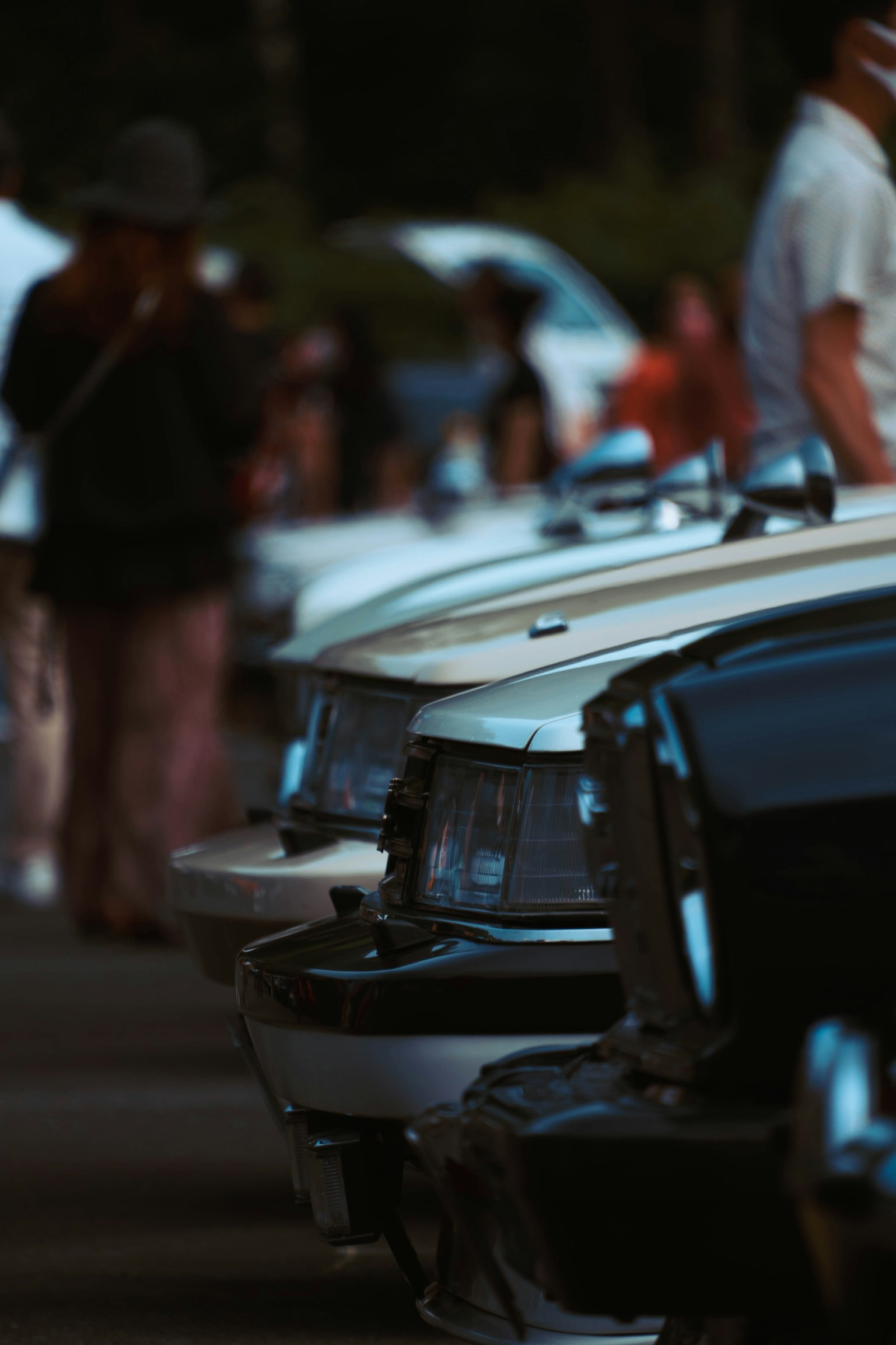 Vista dei retro di auto classiche allineate con persone sullo sfondo