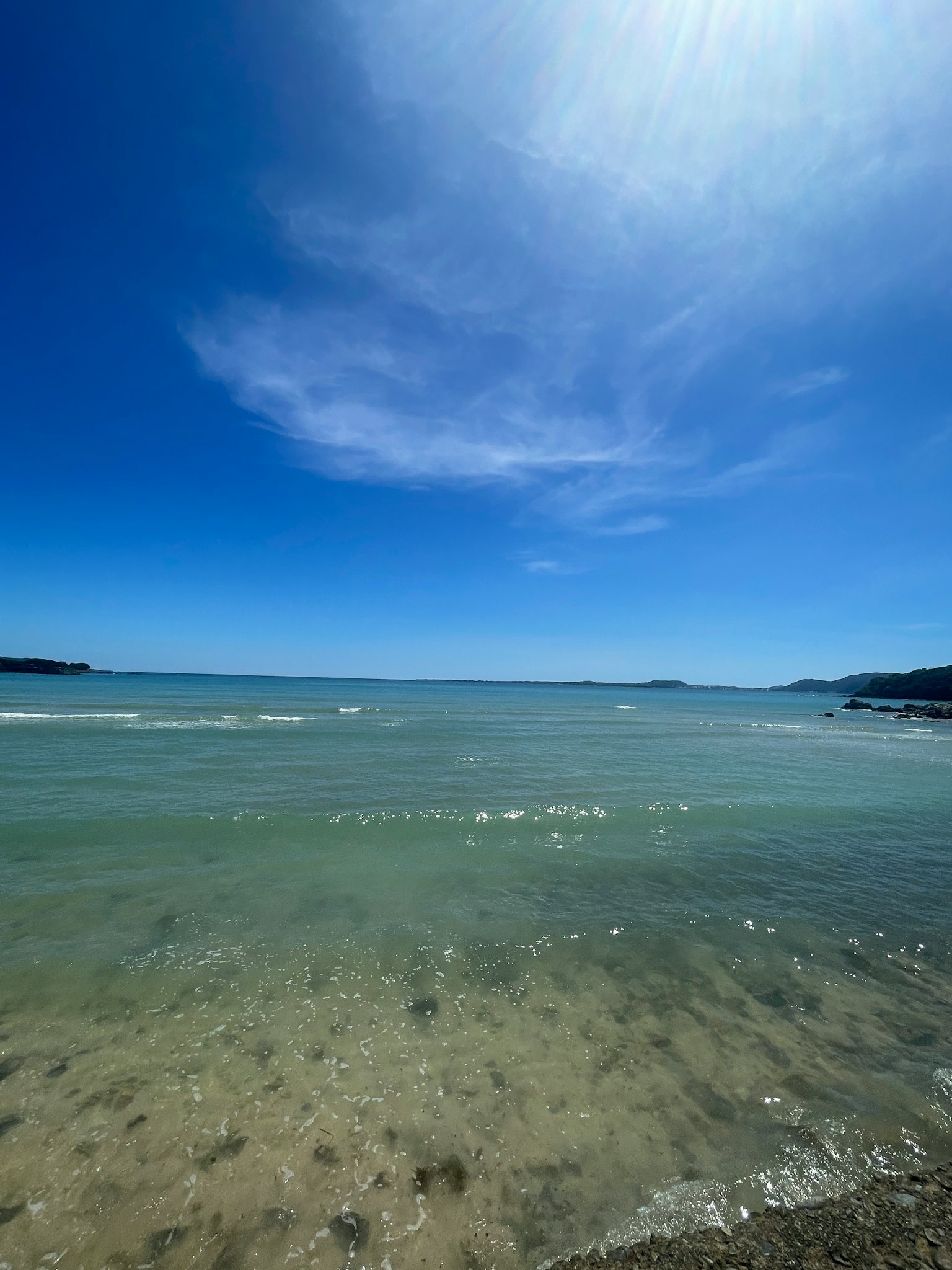 Strandszene mit klarem Wasser und blauem Himmel
