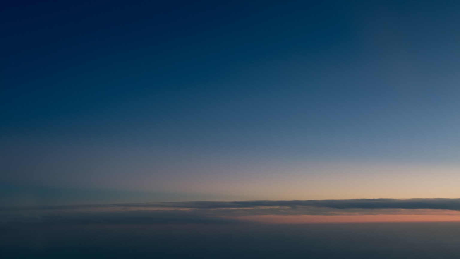 Un ciel serein avec un dégradé de bleu aux teintes douces près de l'horizon