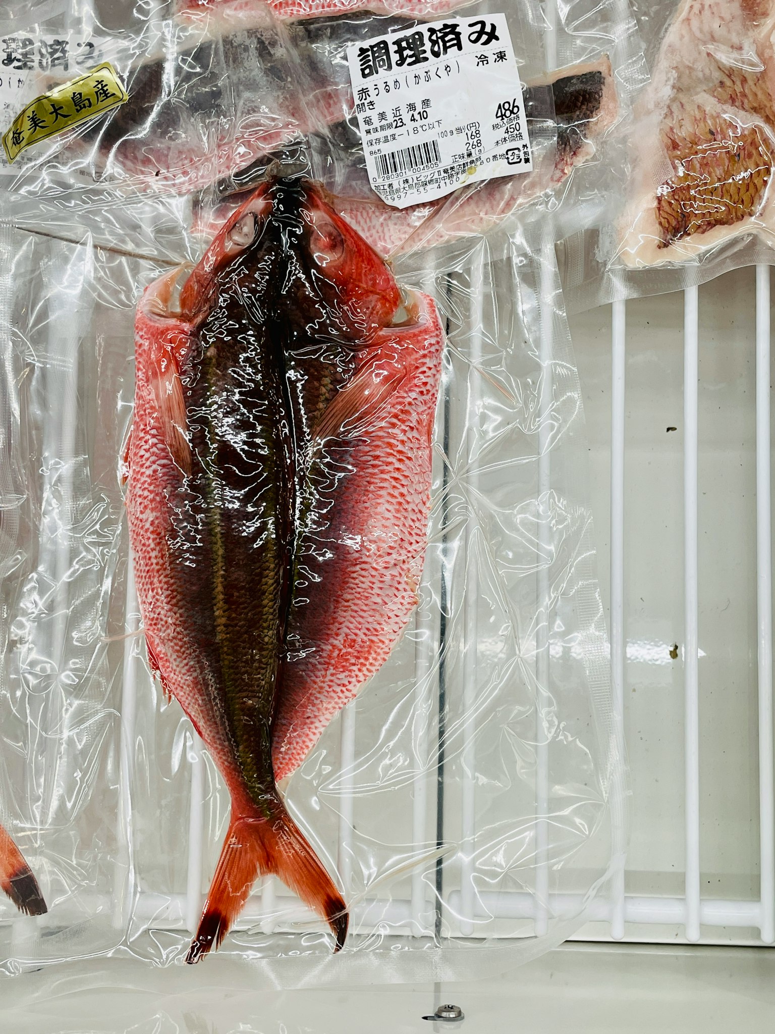 Verpackter Fisch mit roter Haut und sichtbaren schwarzen Schuppen