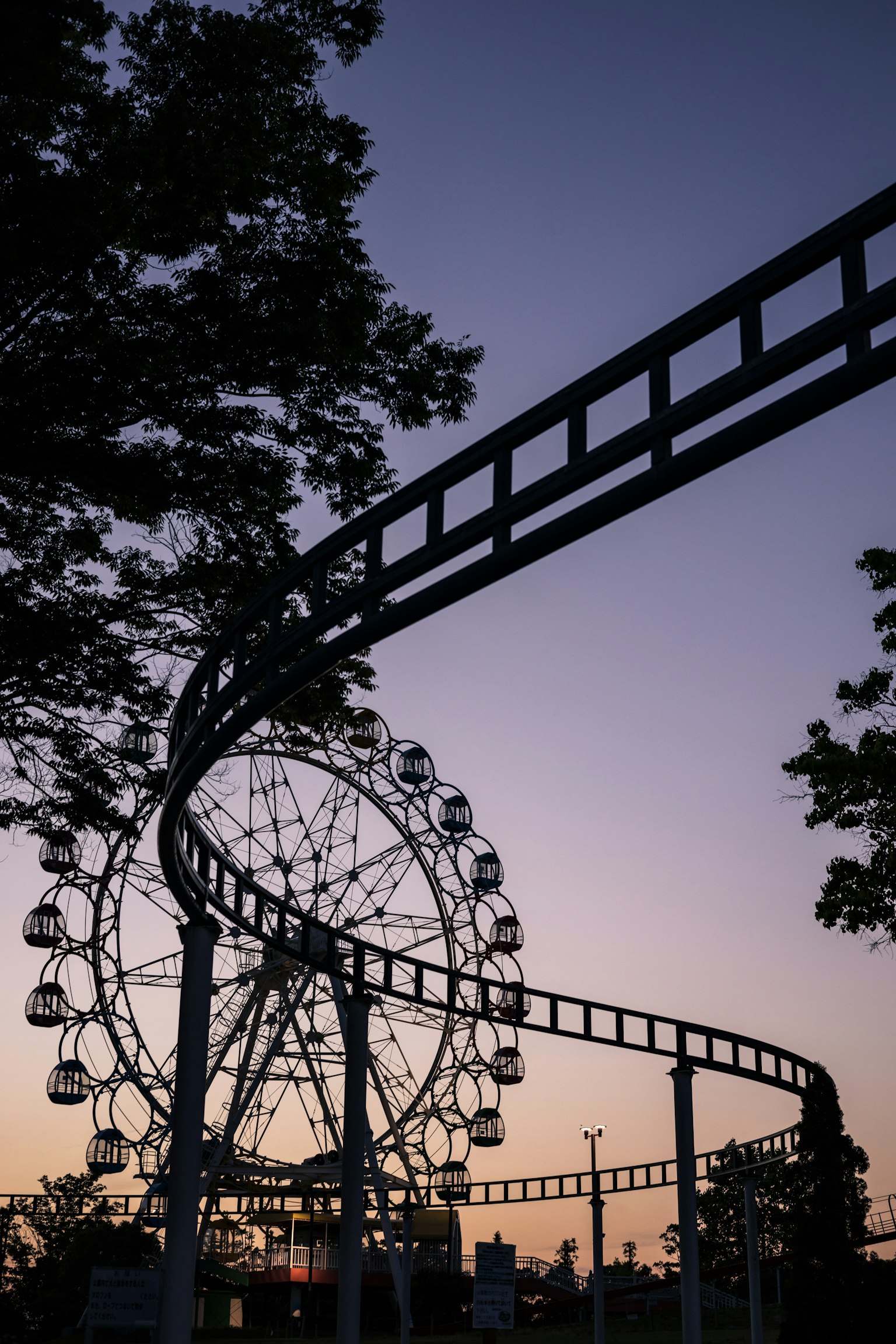 夕暮れの空を背景にした観覧車とその支柱のシルエット
