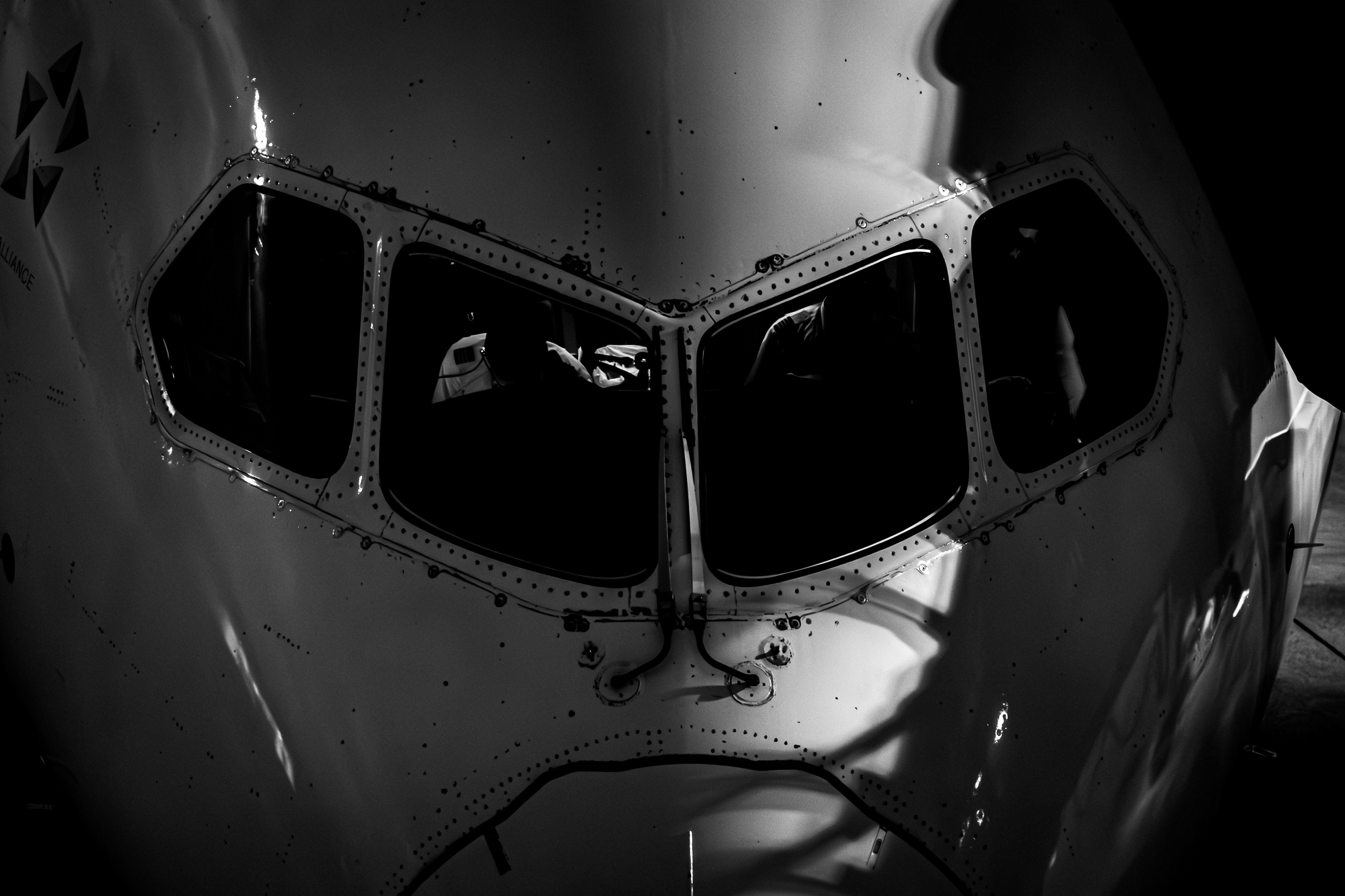 Primer plano en blanco y negro del fuselaje de un avión y sus ventanas
