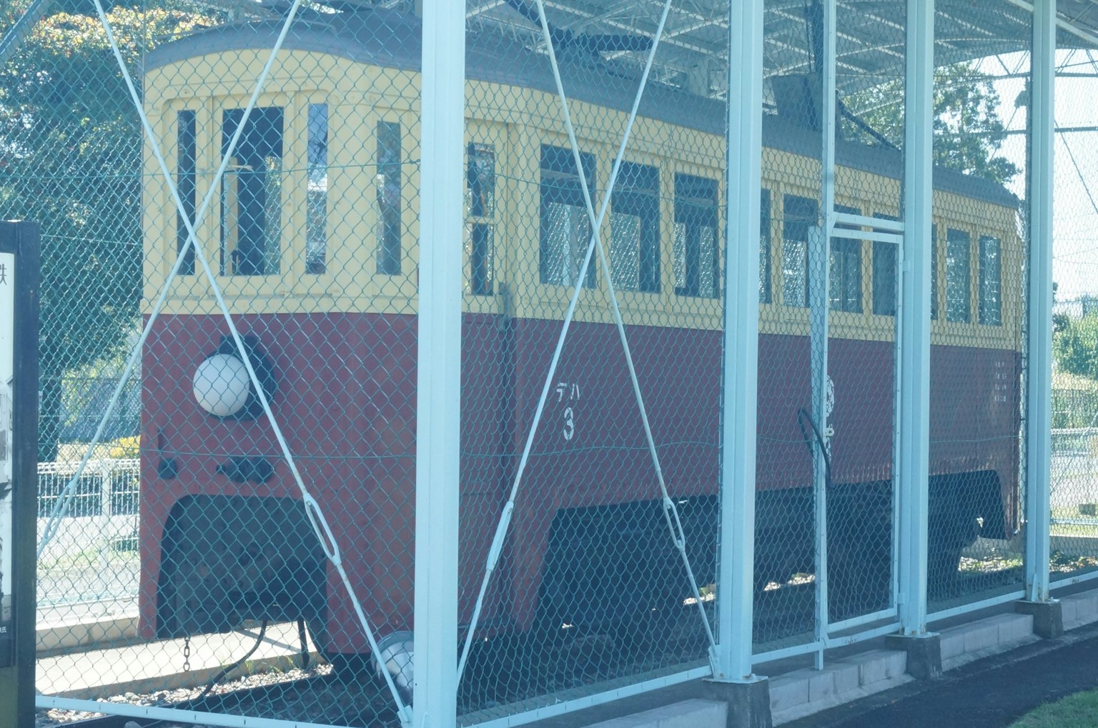 一輛紅色和黃色的老火車在圍欄內展示