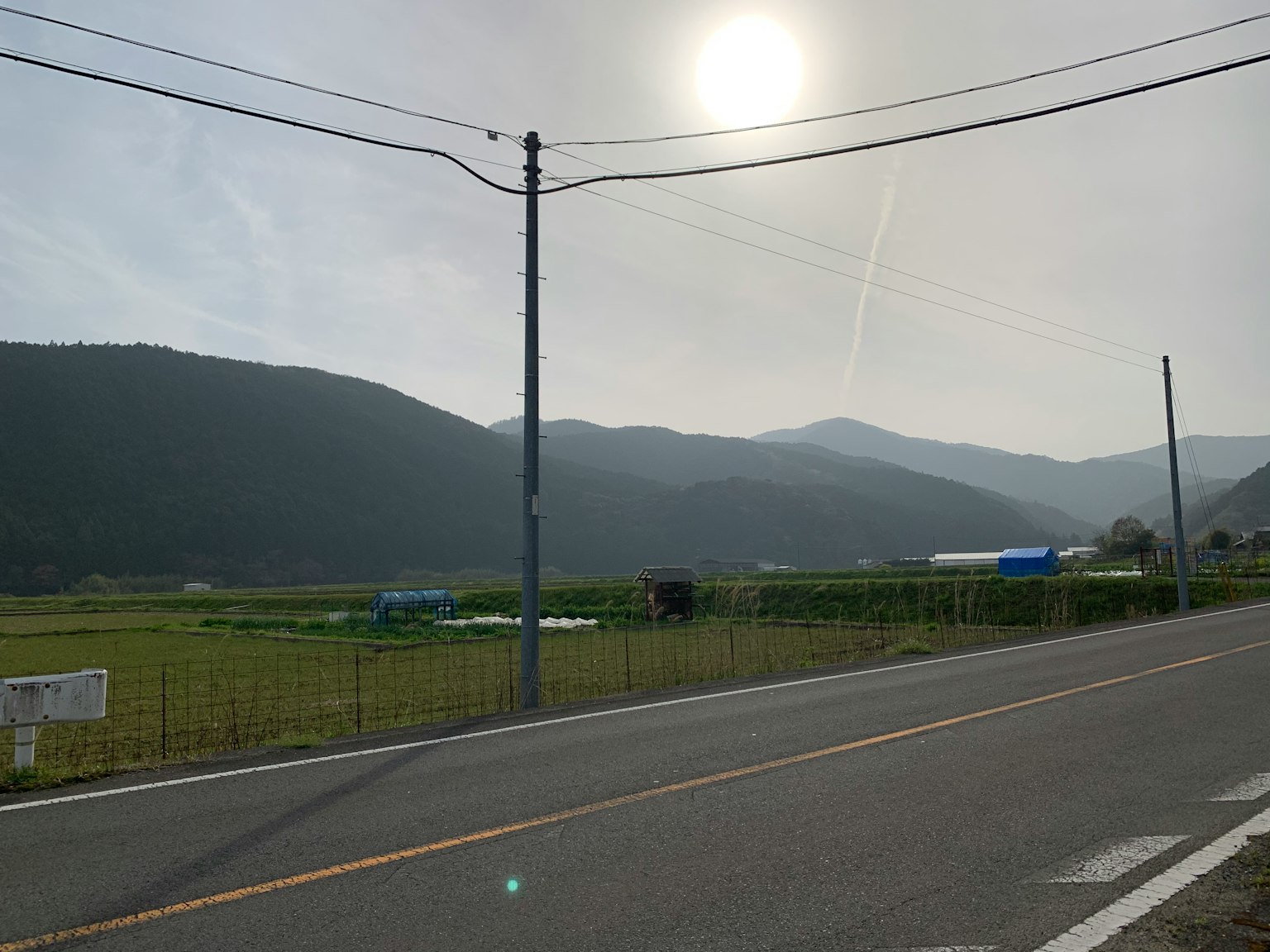 被群山环绕的乡村景观和阳光下的宁静道路