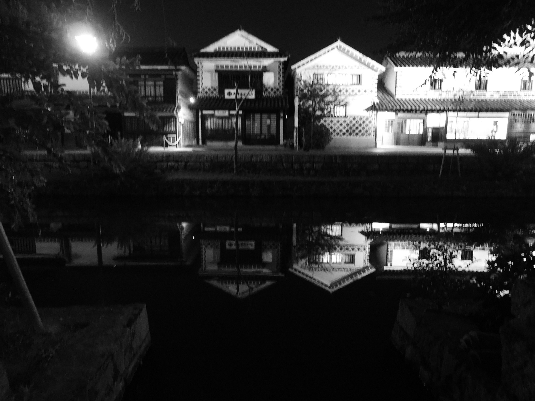 美観地区の夜景に映る白壁の町家と水面の反射