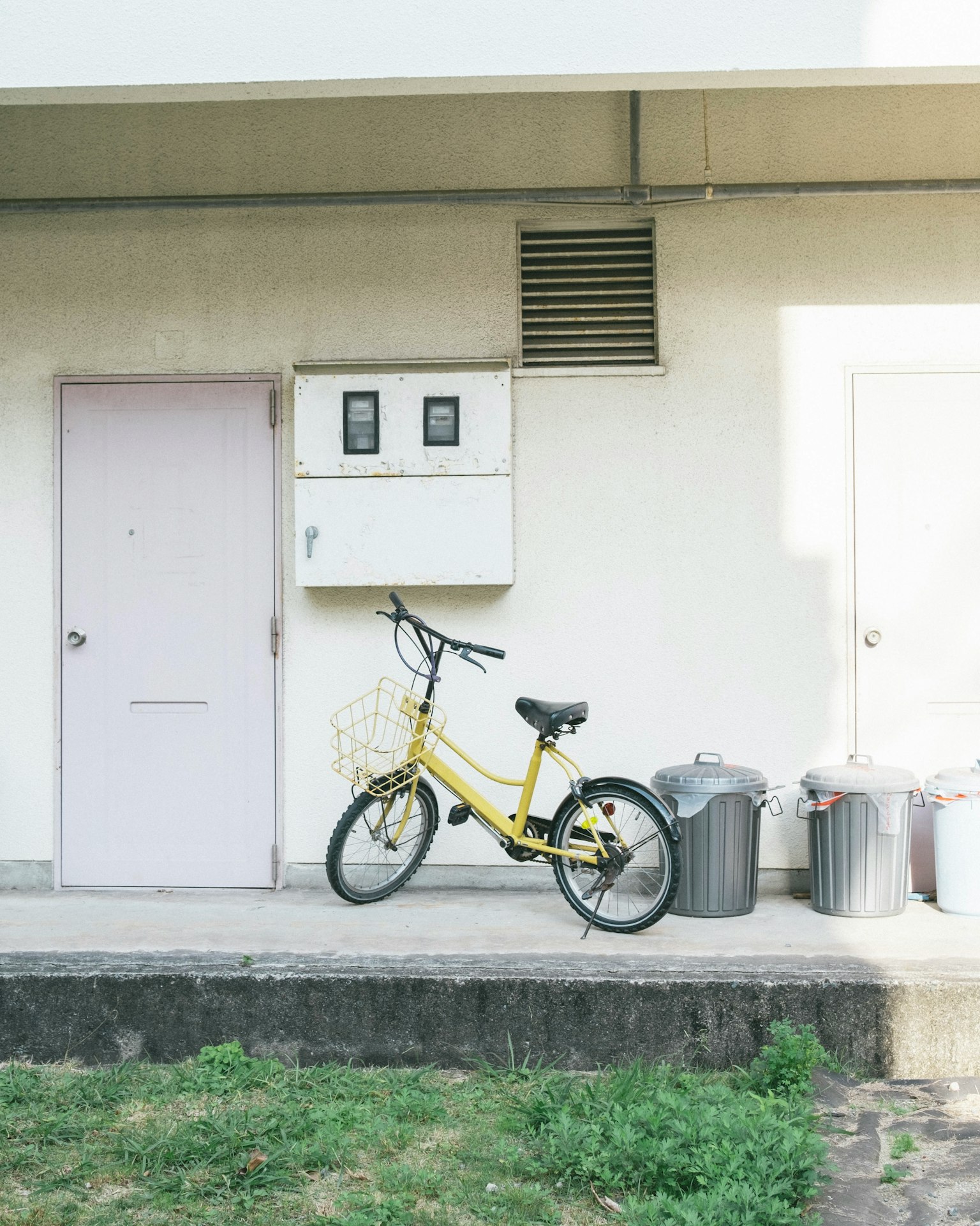 一輛靠在牆上的黃色自行車，周圍環境乾淨