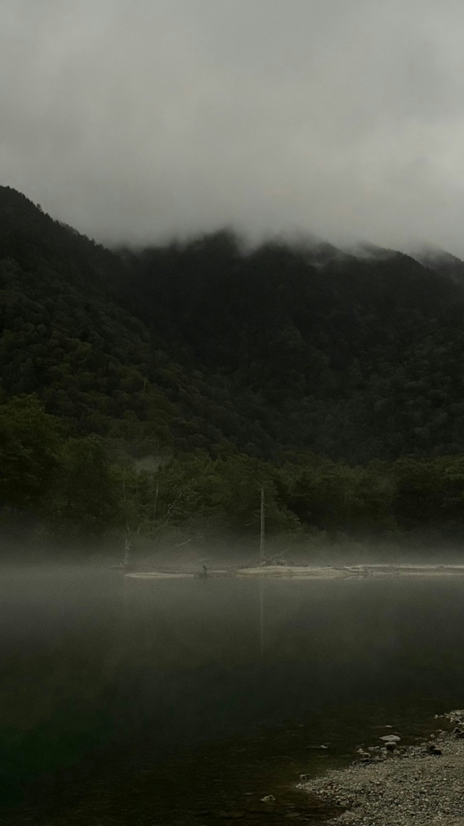 雾气笼罩的山脉与宁静的湖泊场景