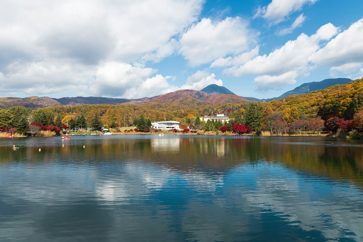Malersicher Blick auf einen See, der bunte Herbstbäume und Berge spiegelt