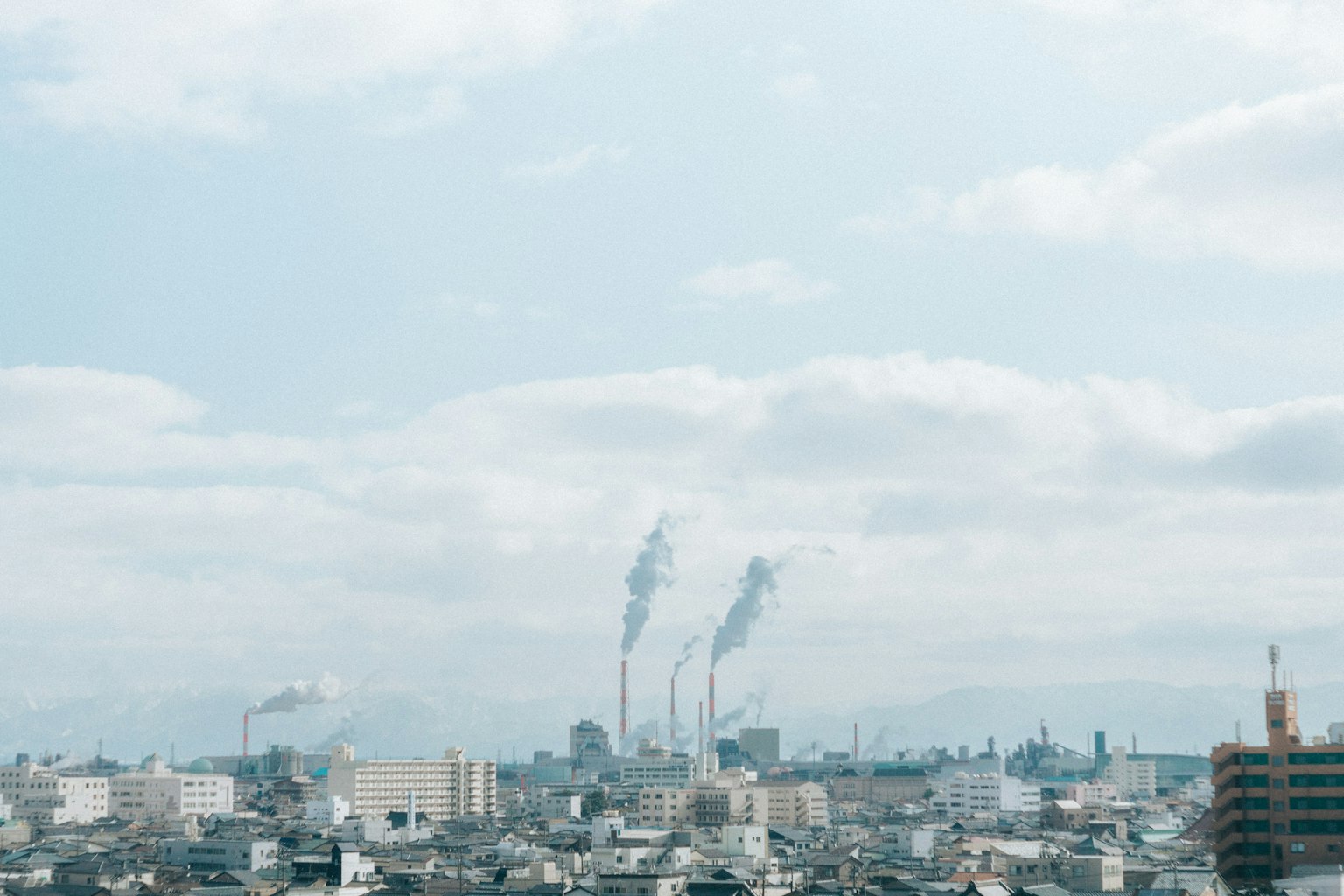 Urban landscape featuring factory chimneys emitting smoke