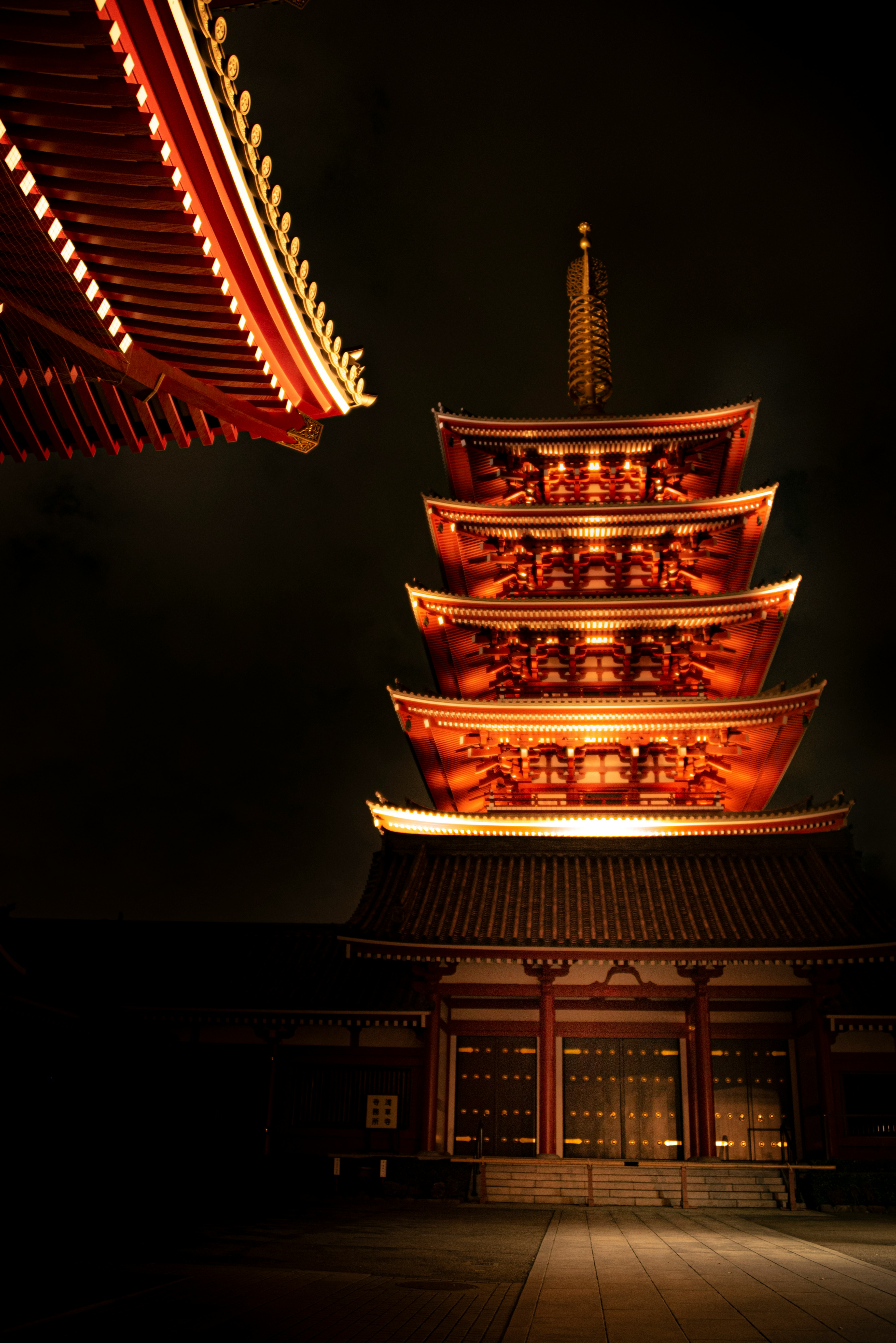 夜のライトアップされた寺院の多層塔と本堂