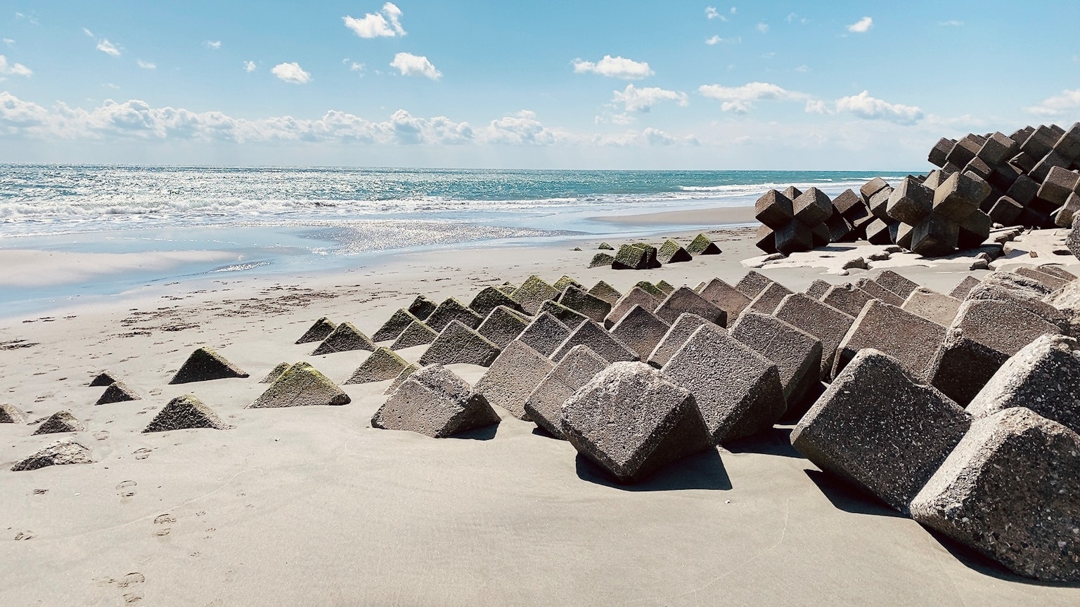 Strandszene mit Betonblöcken und blauem Ozean