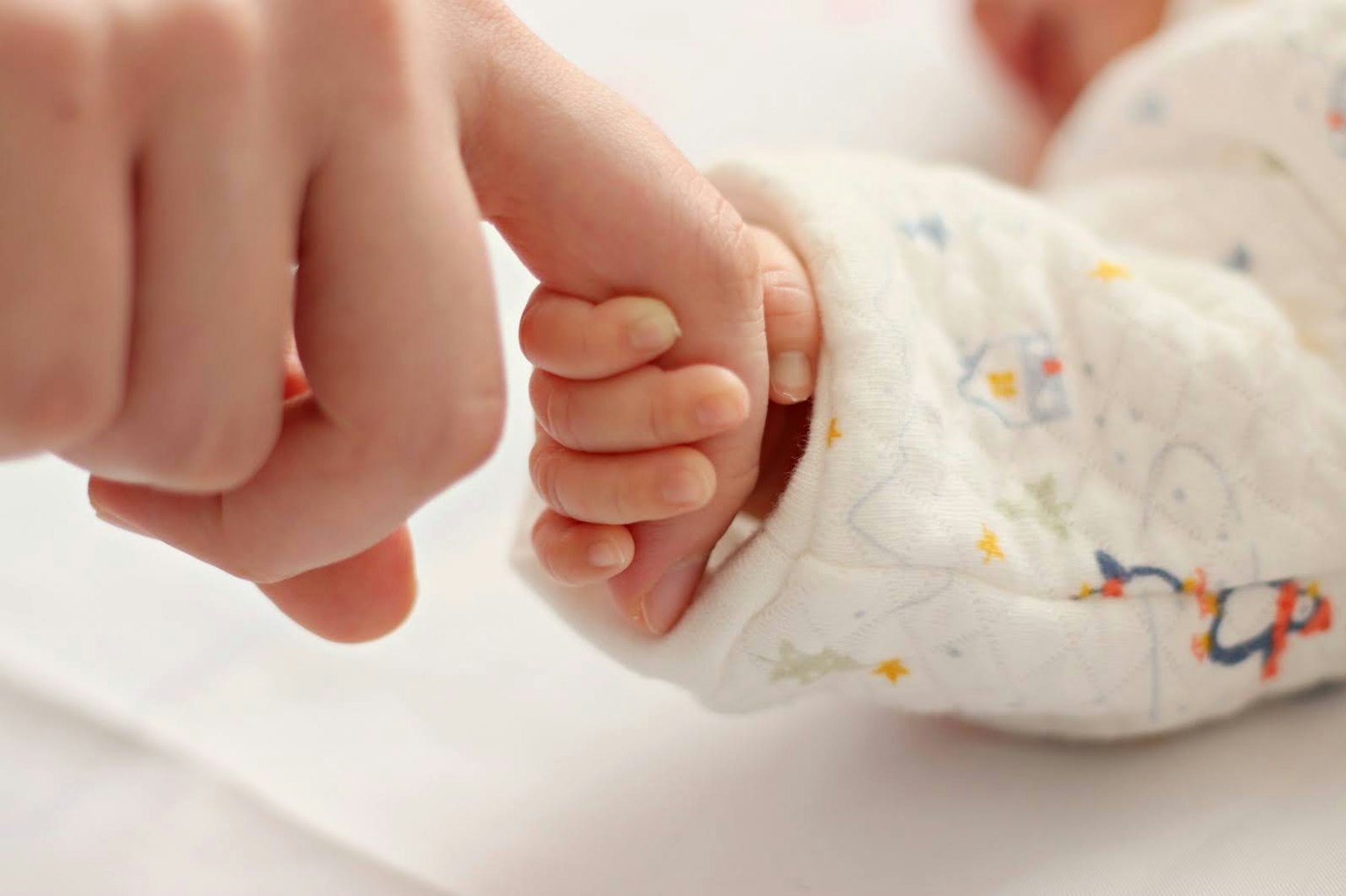 Una scena calda di una piccola mano di bambino che tiene un dito di genitore