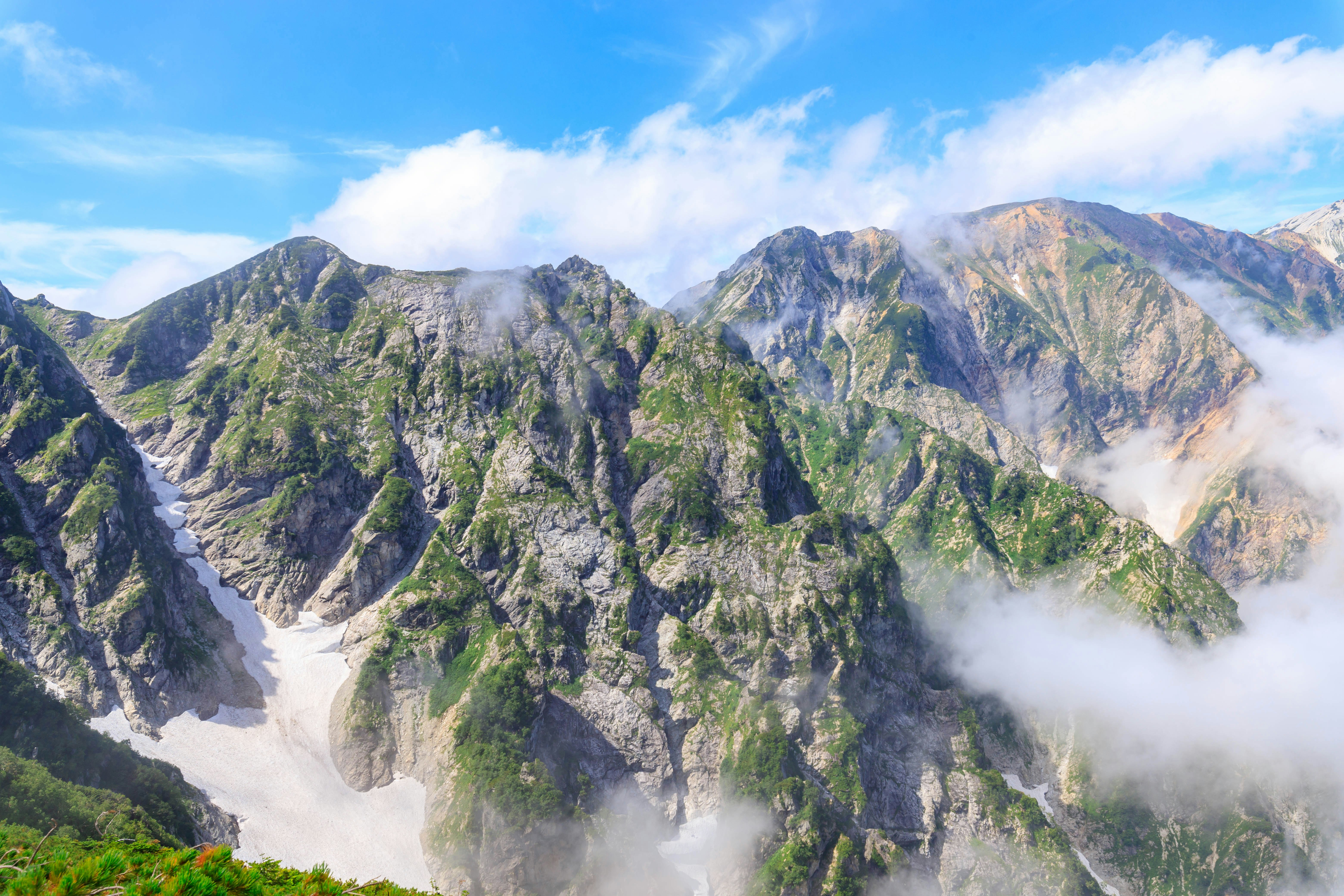 霧のかかった山並みと緑の渓谷