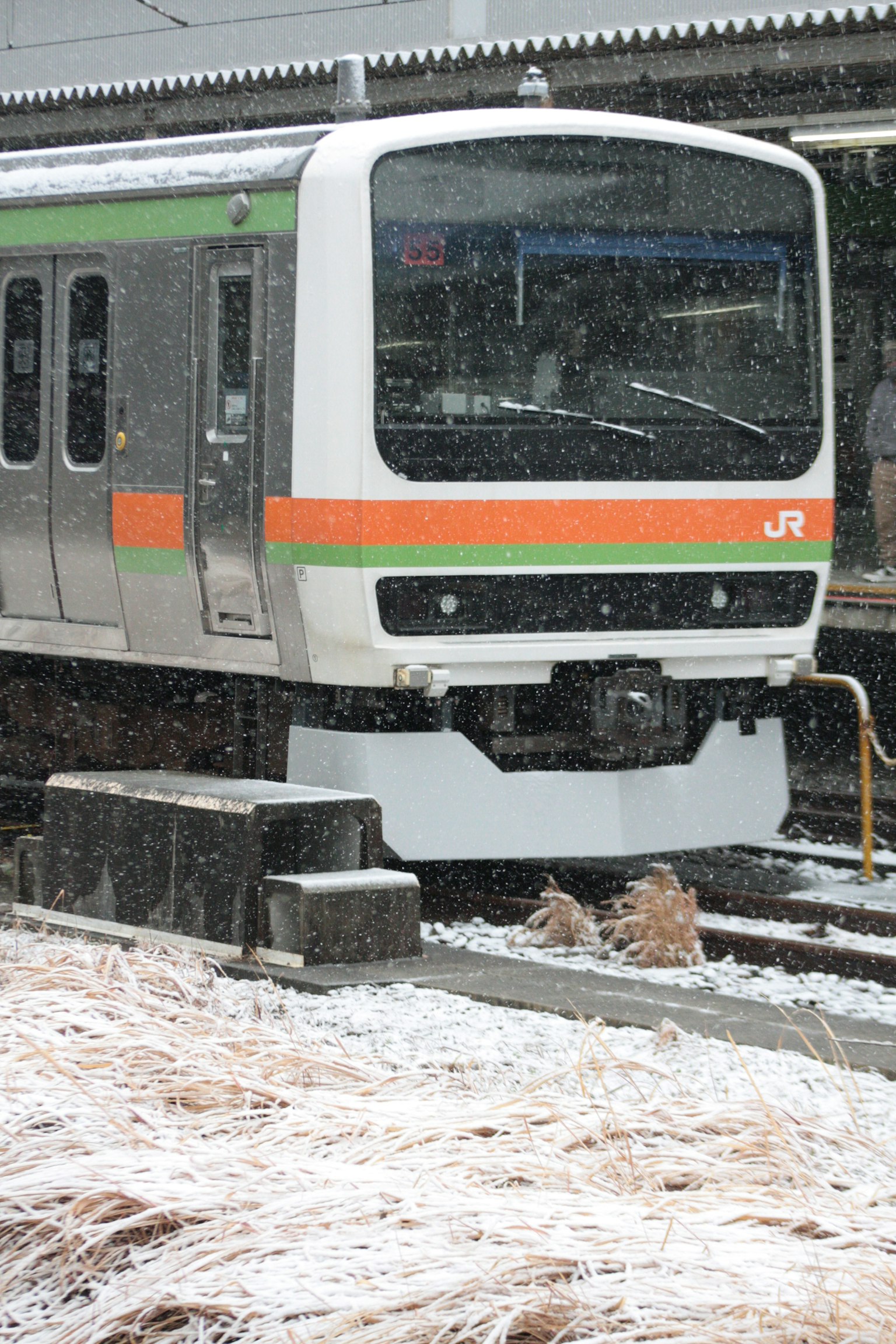 JR train in the snow at a station