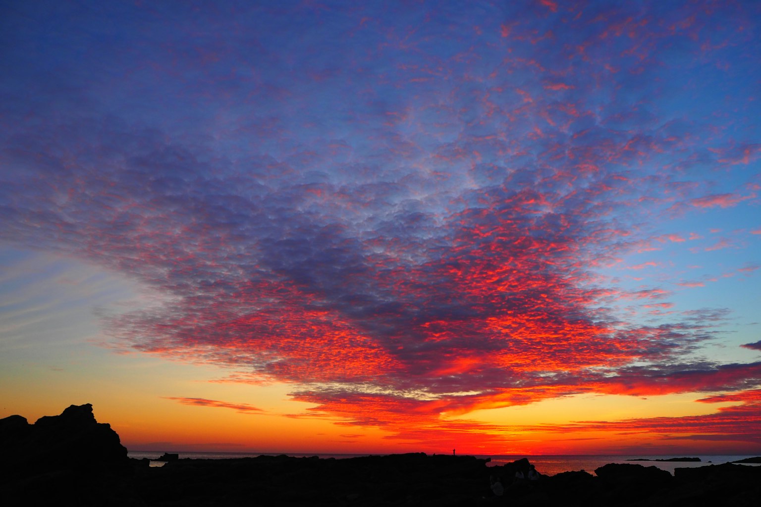 Stupendo cielo al tramonto sopra l'oceano nuvole rosse e arancioni vivaci