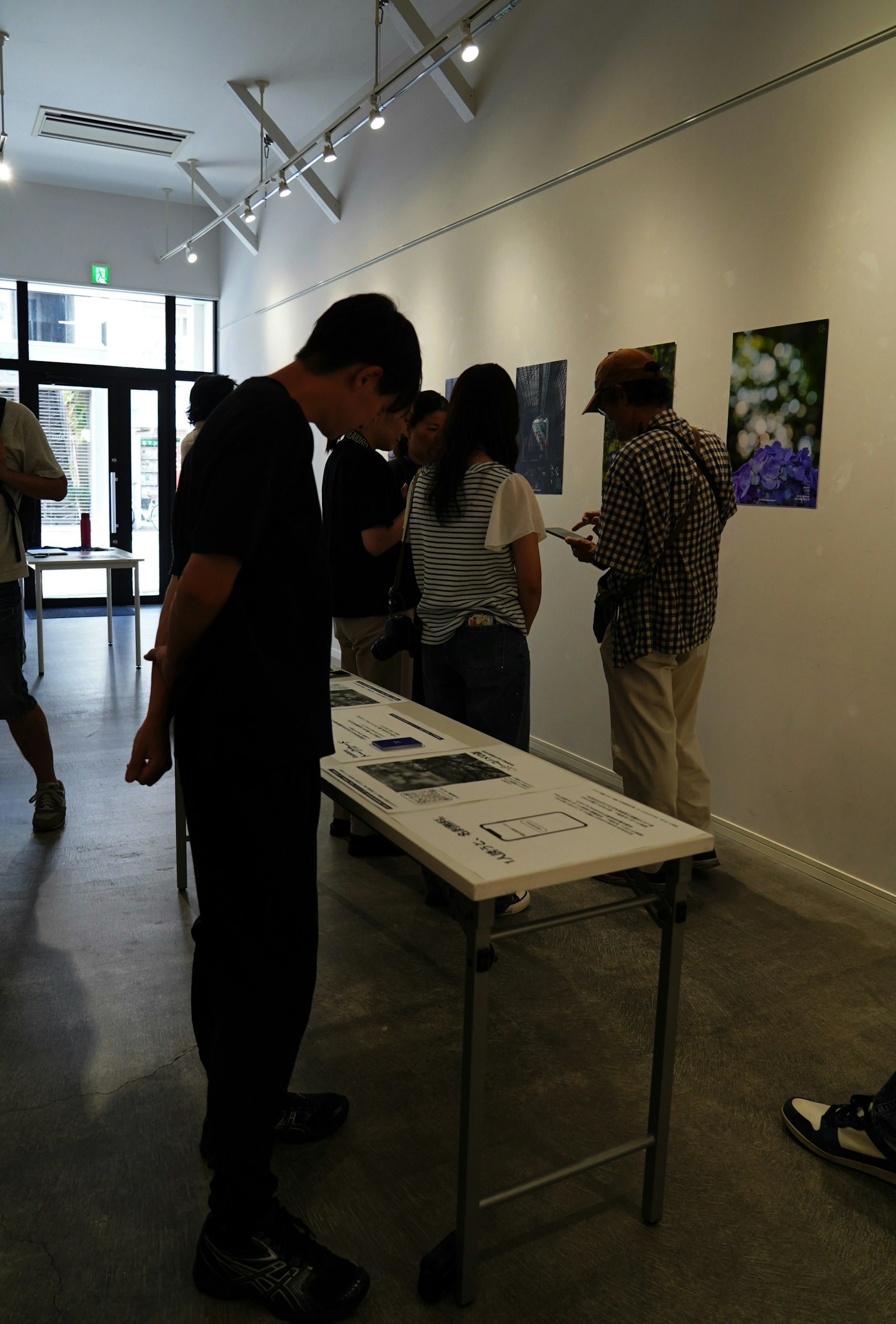 Personas observando obras de arte en una galería con obras expuestas