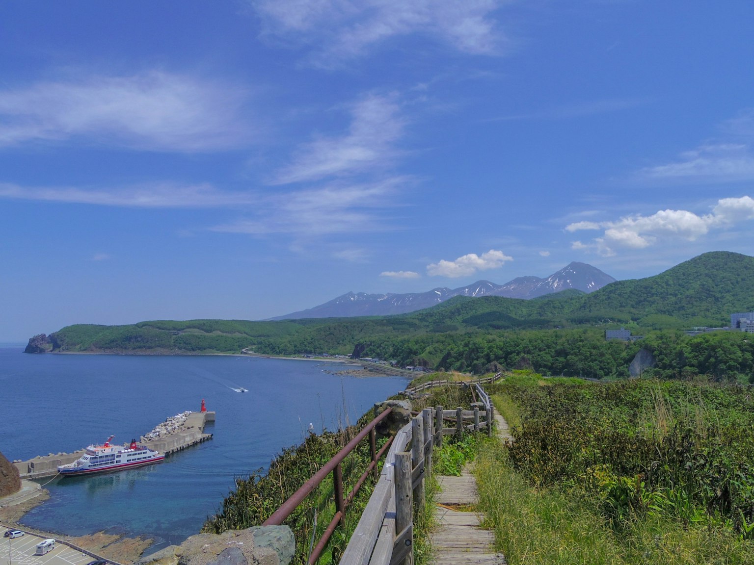 Scenic coastal pathway with blue sea and sky mountains in the background
