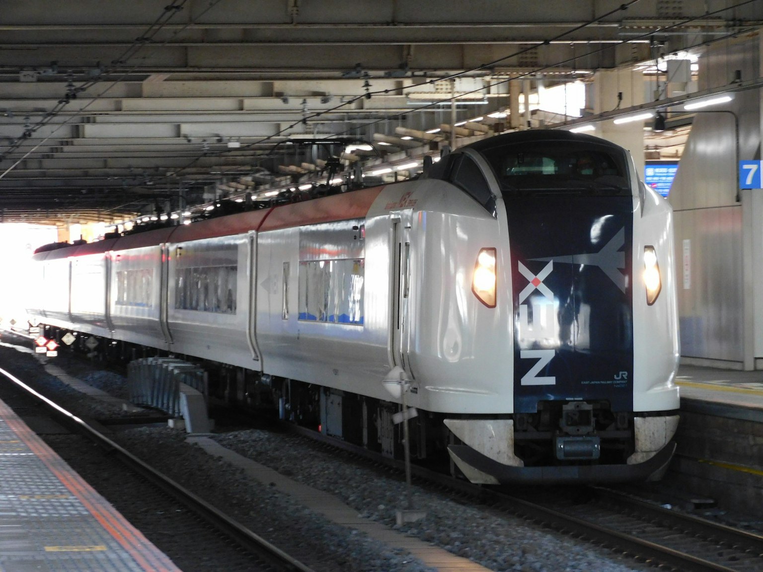 A white train stopped at a station