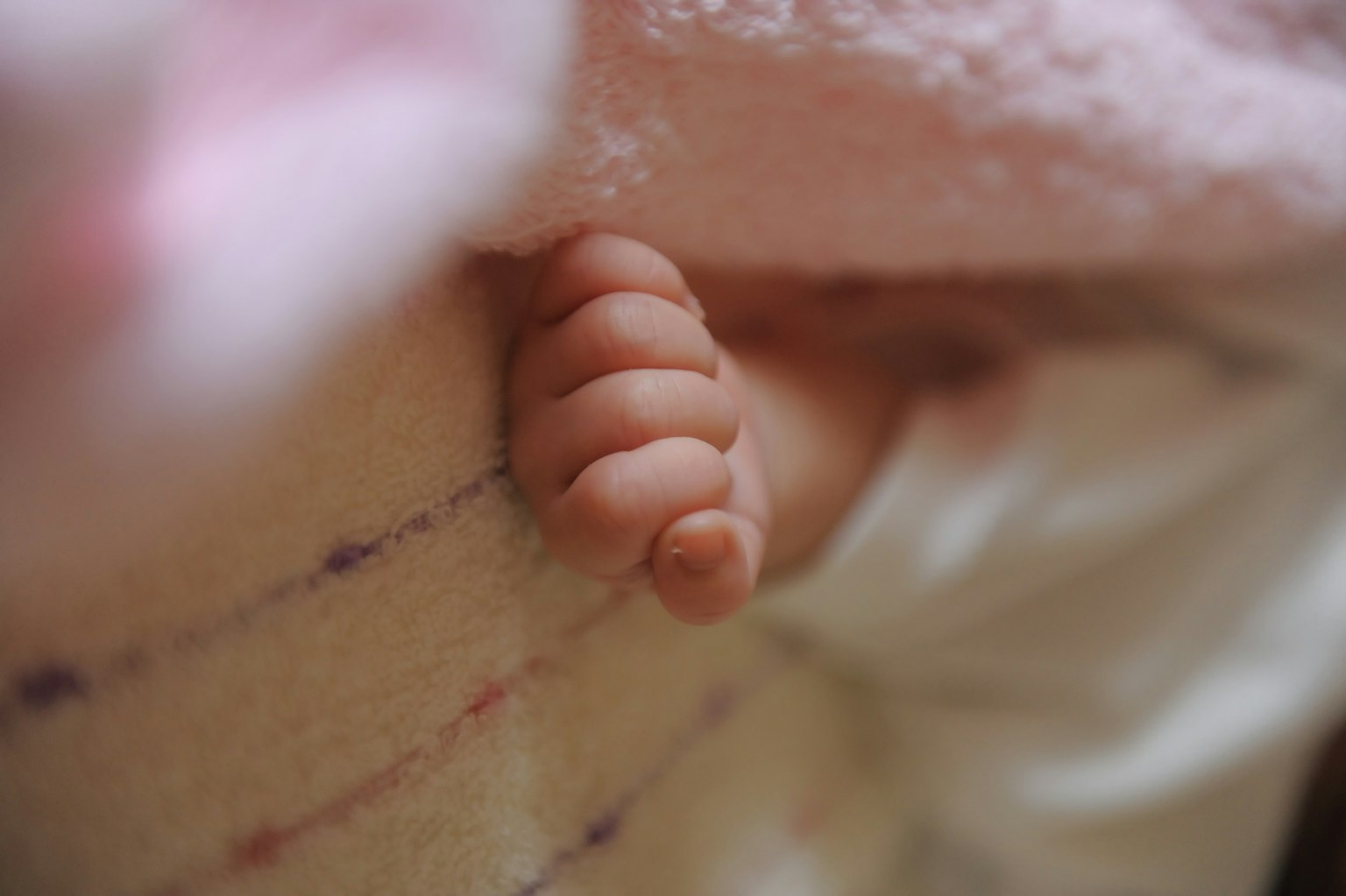 Un pied di bambino che spunta da sotto una coperta