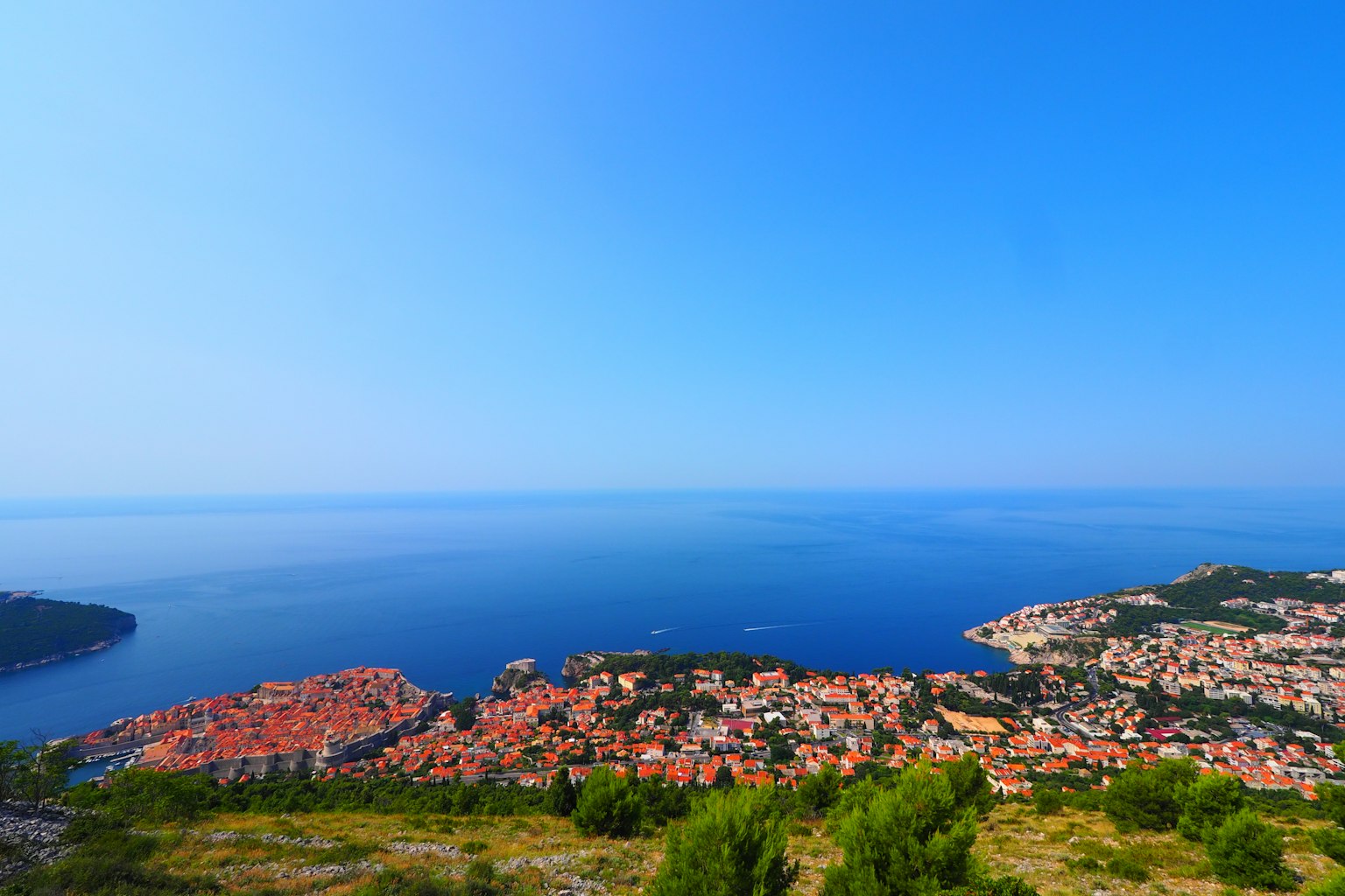 Bella costa di Dubrovnik con case a tetto rosso sotto un cielo e un mare blu