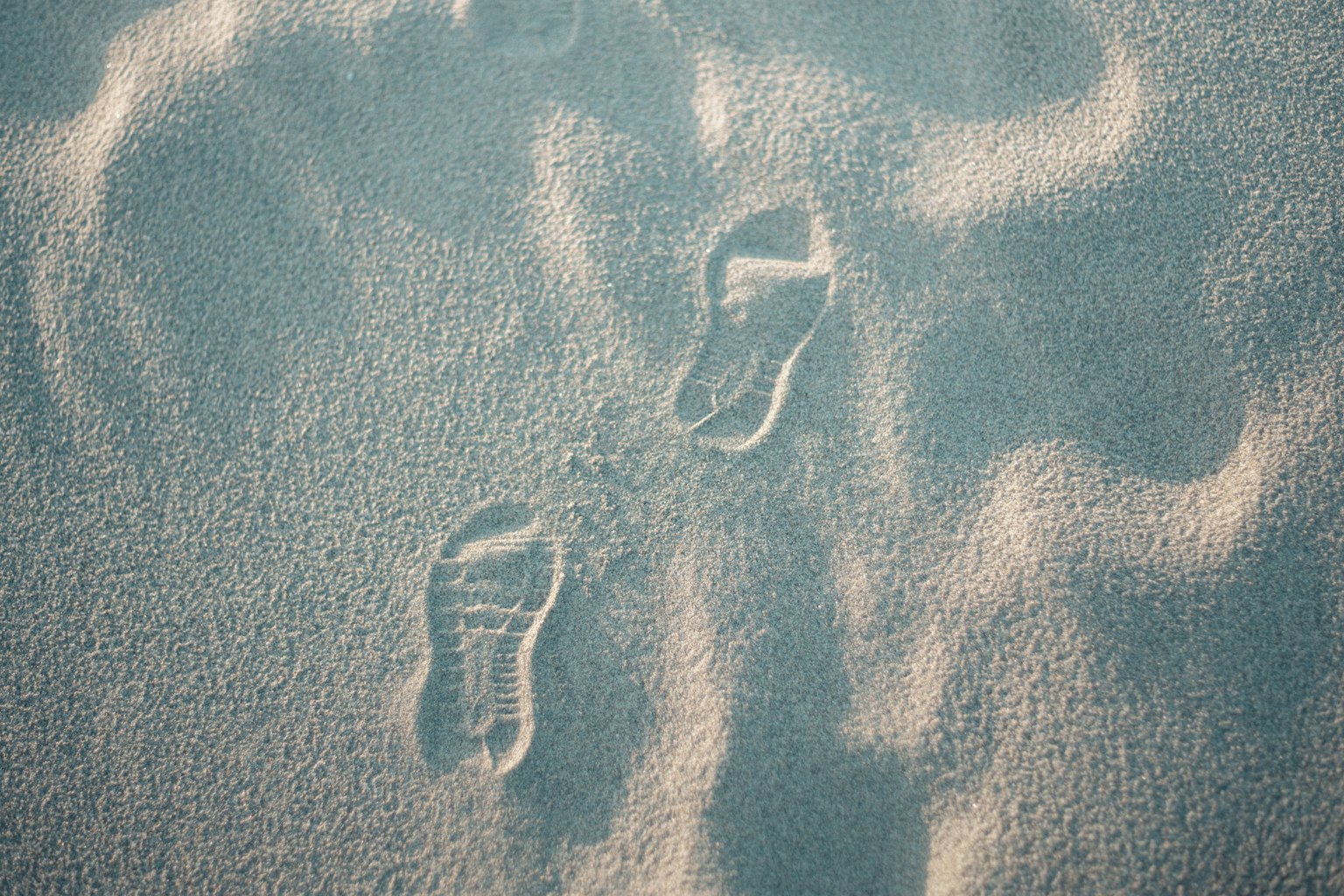Fußabdrücke im Sandstrand mit Wellenmustern