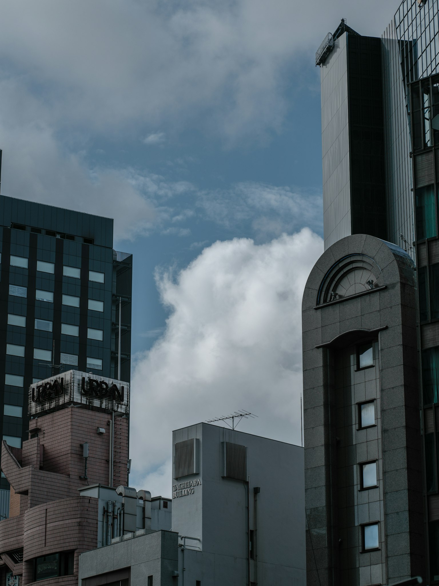 Stadtlandschaft mit Hochhäusern und Wolken vor blauem Himmel