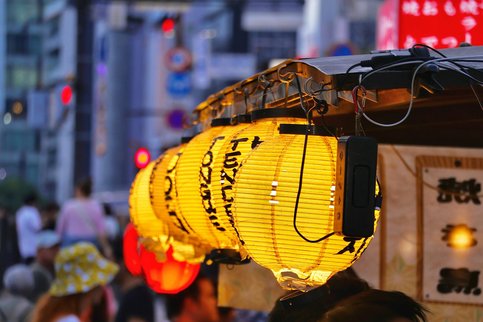 夜の街並みに浮かぶ提灯の明かりと人々の姿