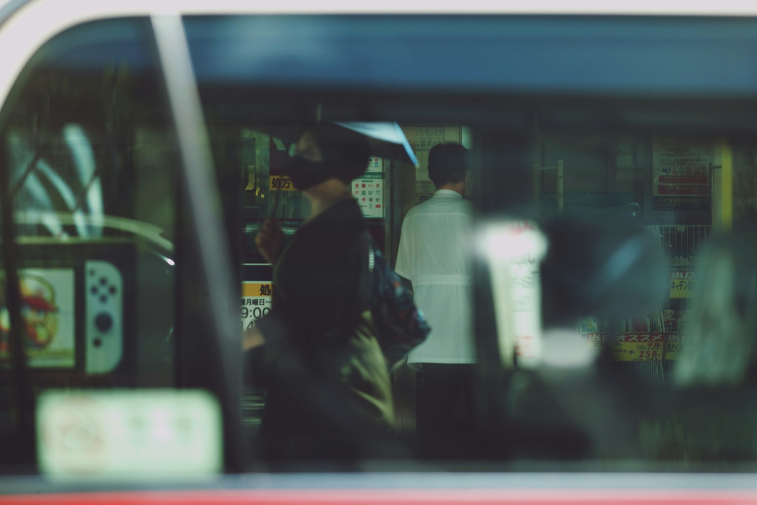 透过公交车窗可见的城市背景中的人们