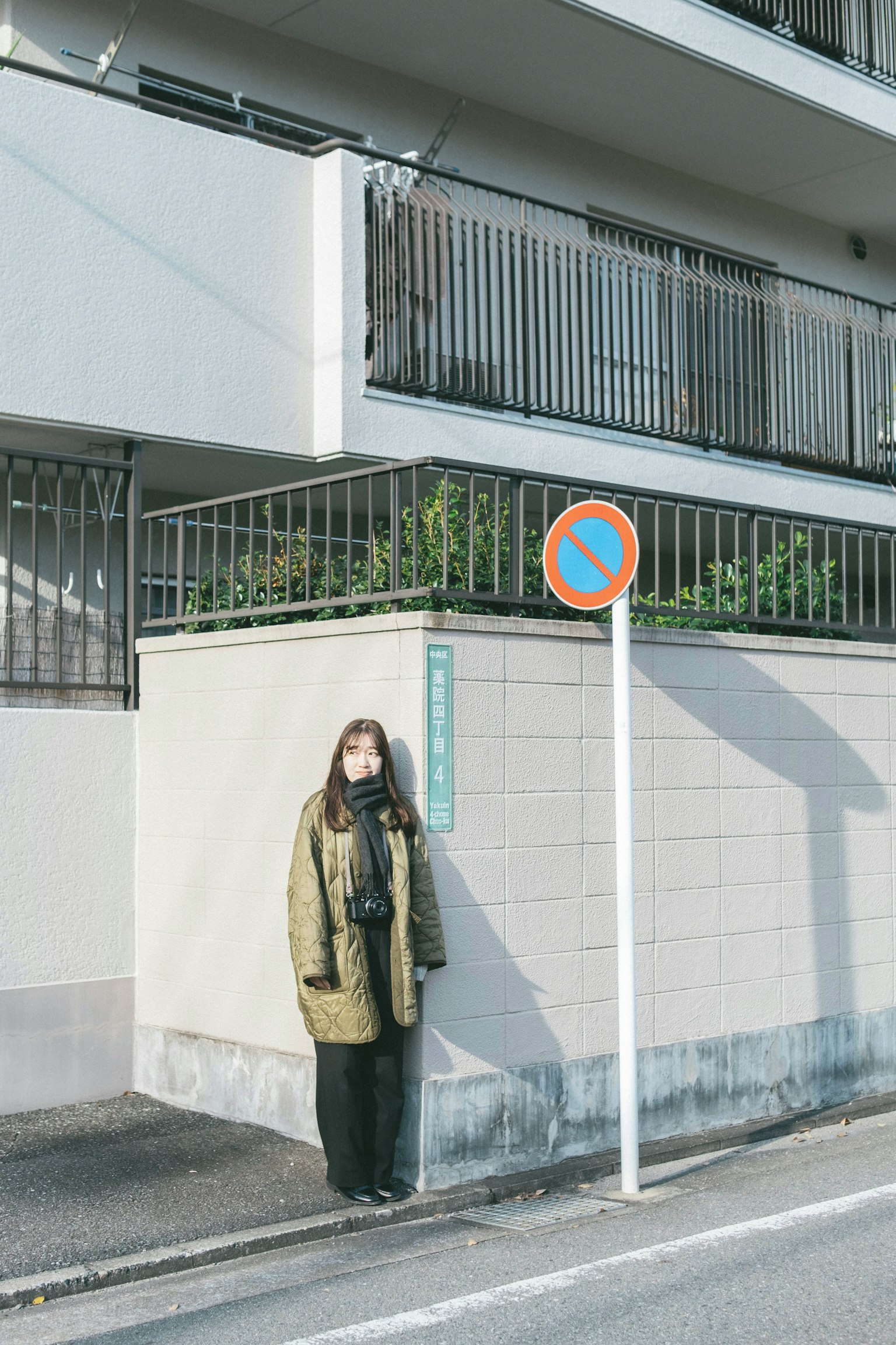 Donna in piedi all'angolo di una strada vicino a un edificio