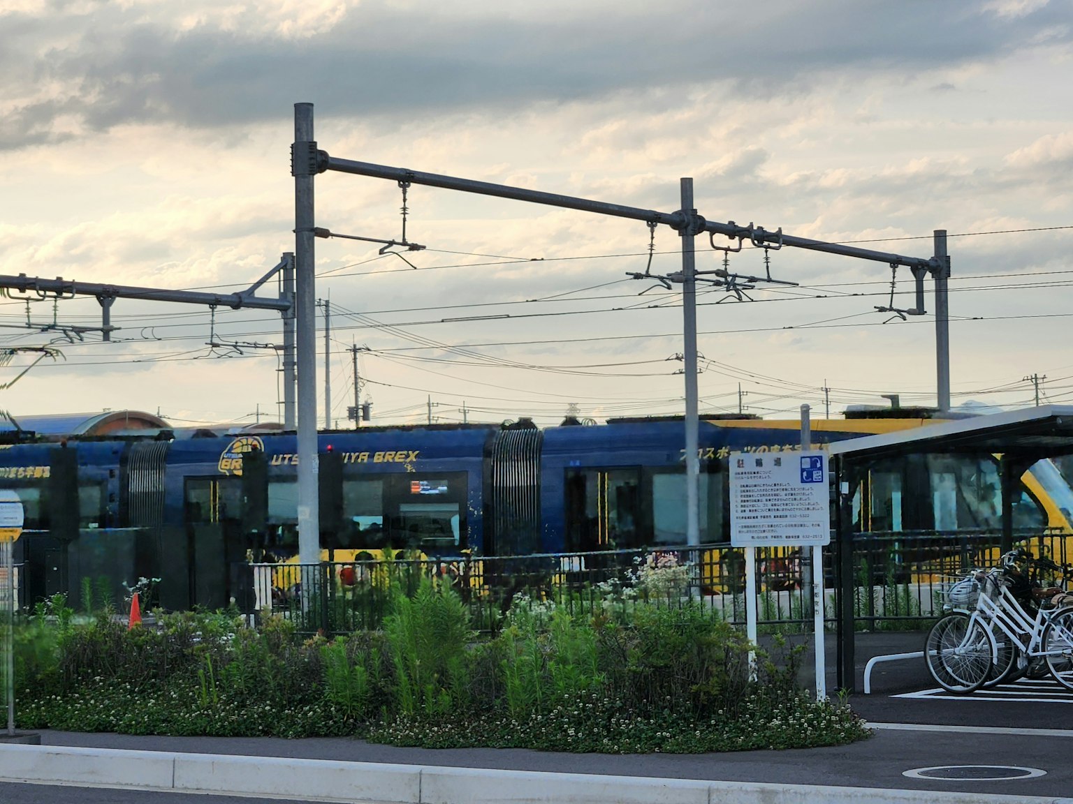 Bahnhofszene mit Gleisen und einem Zug umgeben von Grünflächen