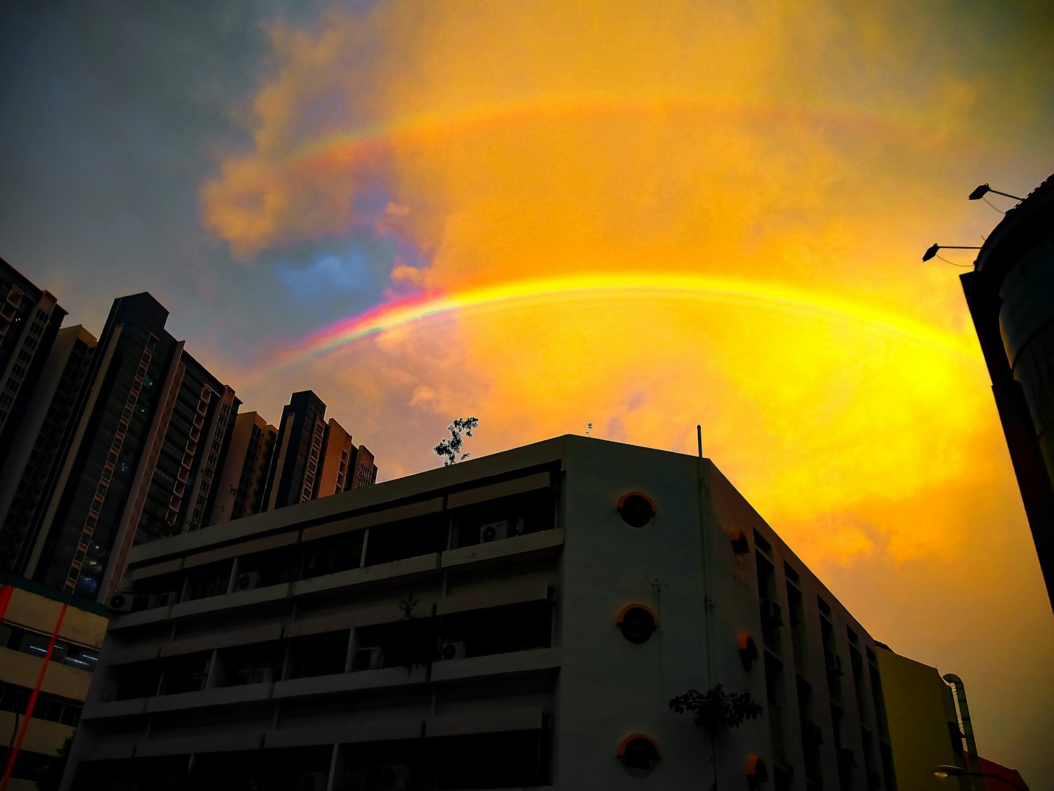Arcobaleno sopra un cielo al tramonto con grattacieli