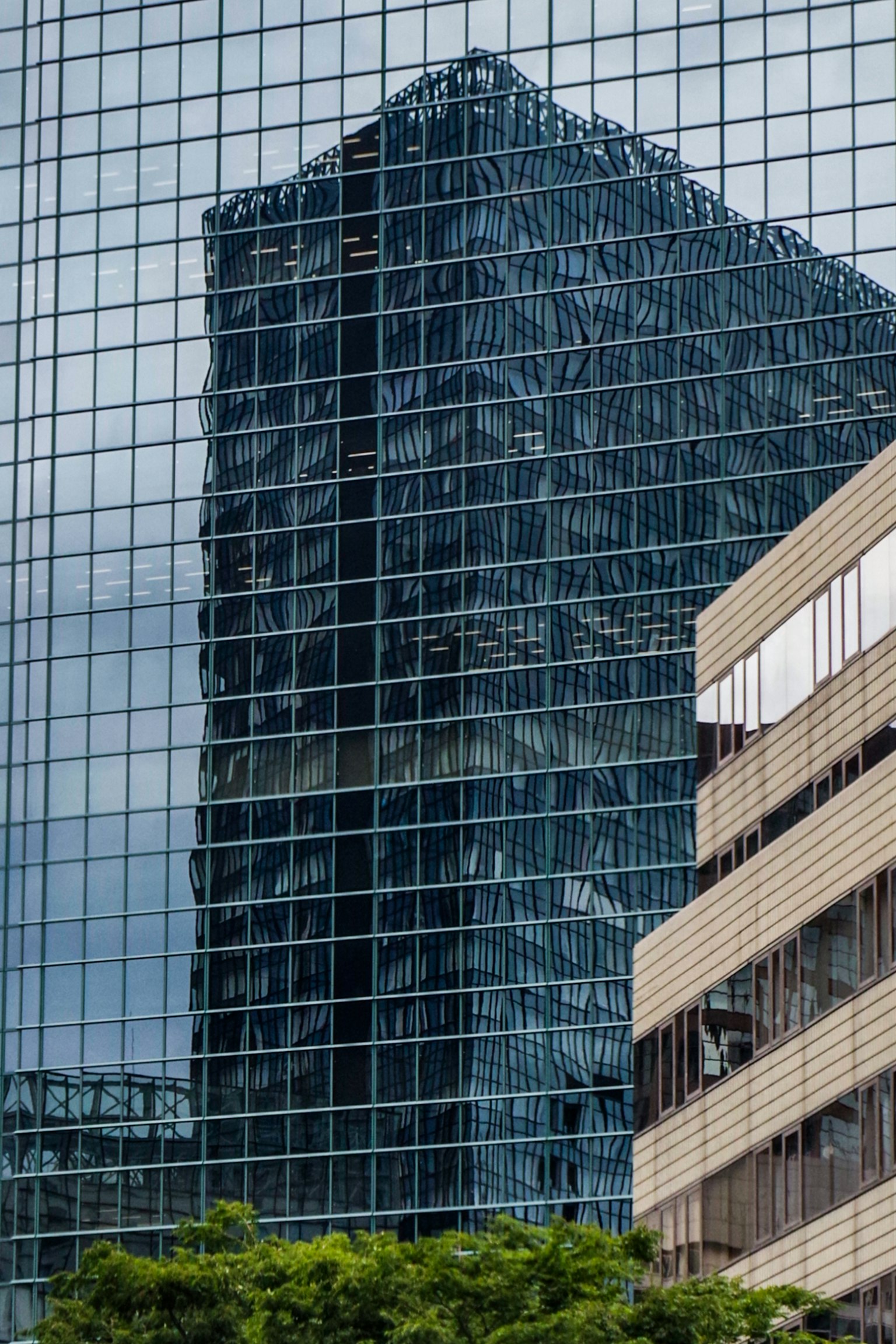 Reflejo de un rascacielos en la fachada de vidrio en un entorno urbano