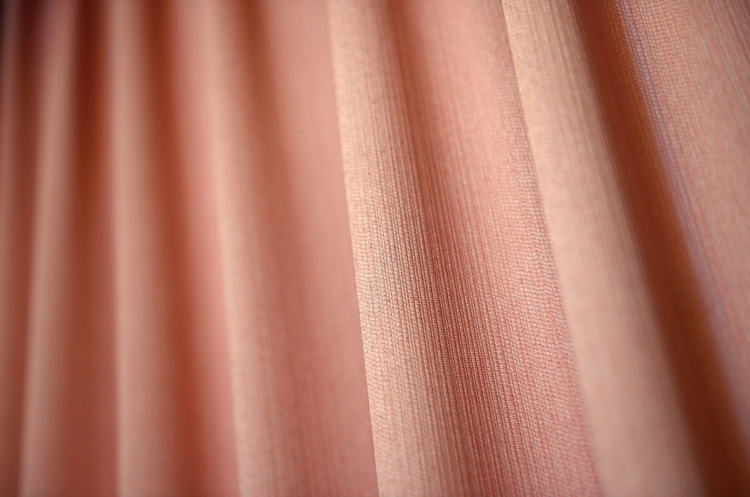 Nahaufnahme von strukturiertem rosa Vorhangstoff mit Falten