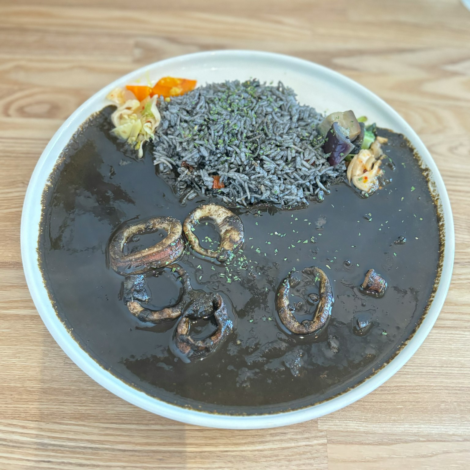 黑色汤配米饭和蔬菜的菜肴
